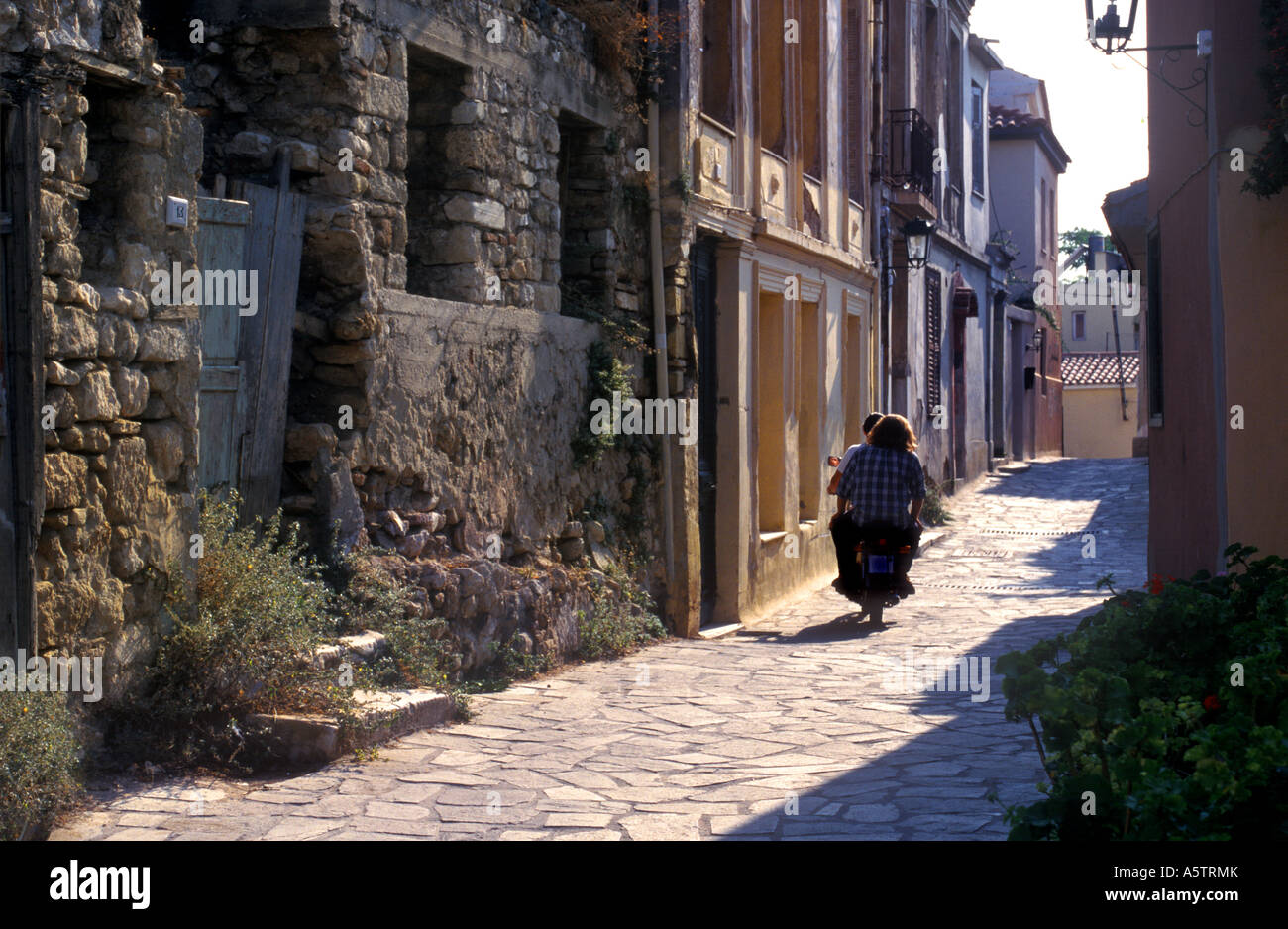 Moto Scooter con l uomo e la donna di equitazione in vicolo, Atene Grecia Foto Stock