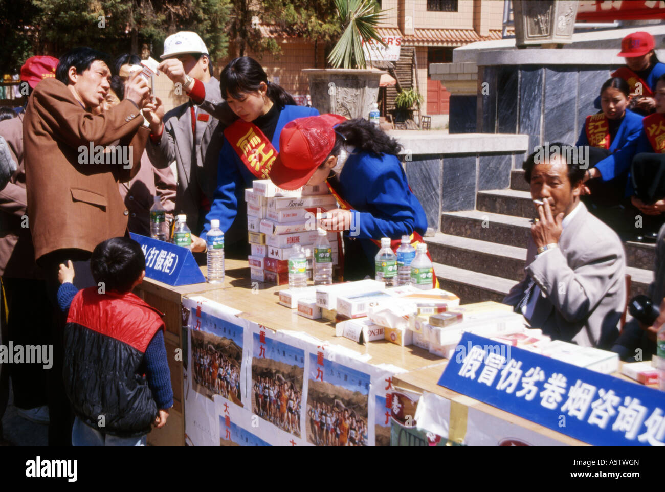 La popolazione locale consente di visualizzare un display ufficiale di confiscare merci contraffatte,Chengdu,provincia di Sichuan, in Cina. Foto Stock