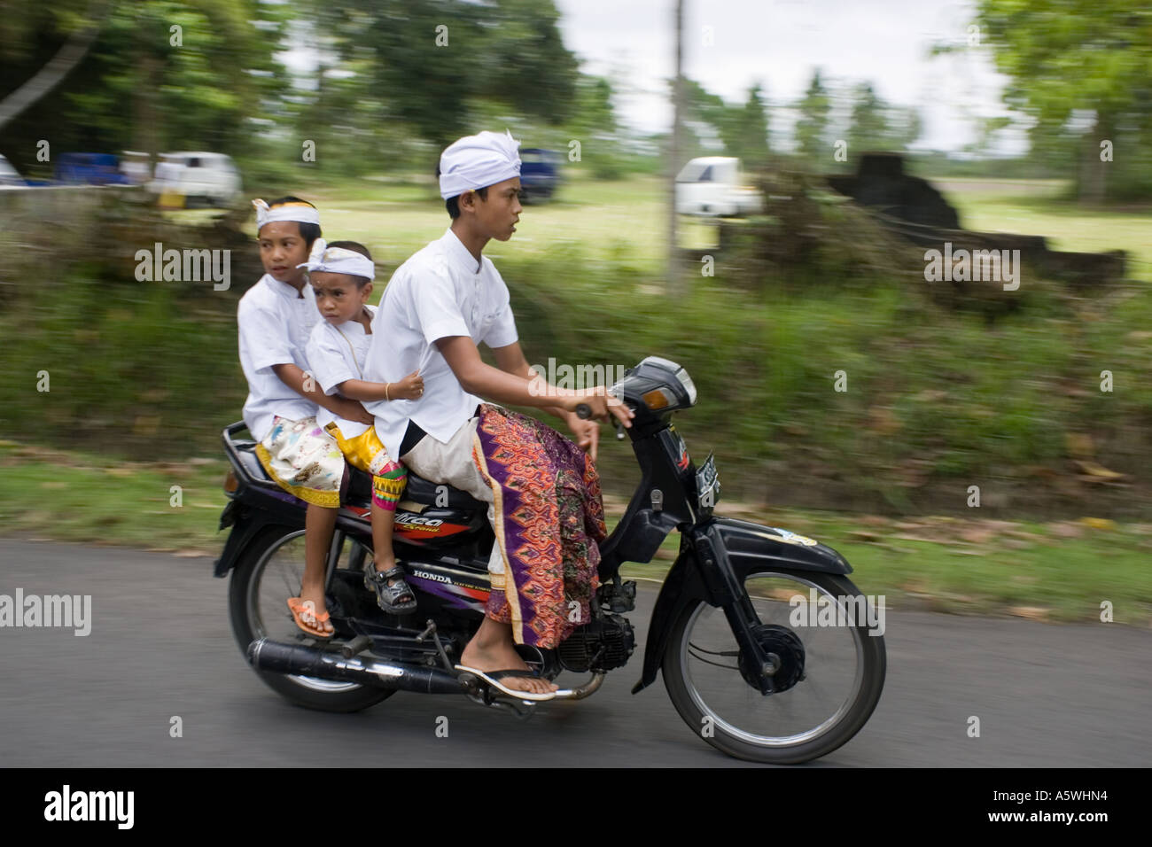 Ragazzi intraditional costume sul moto Bali Indonesia Foto Stock