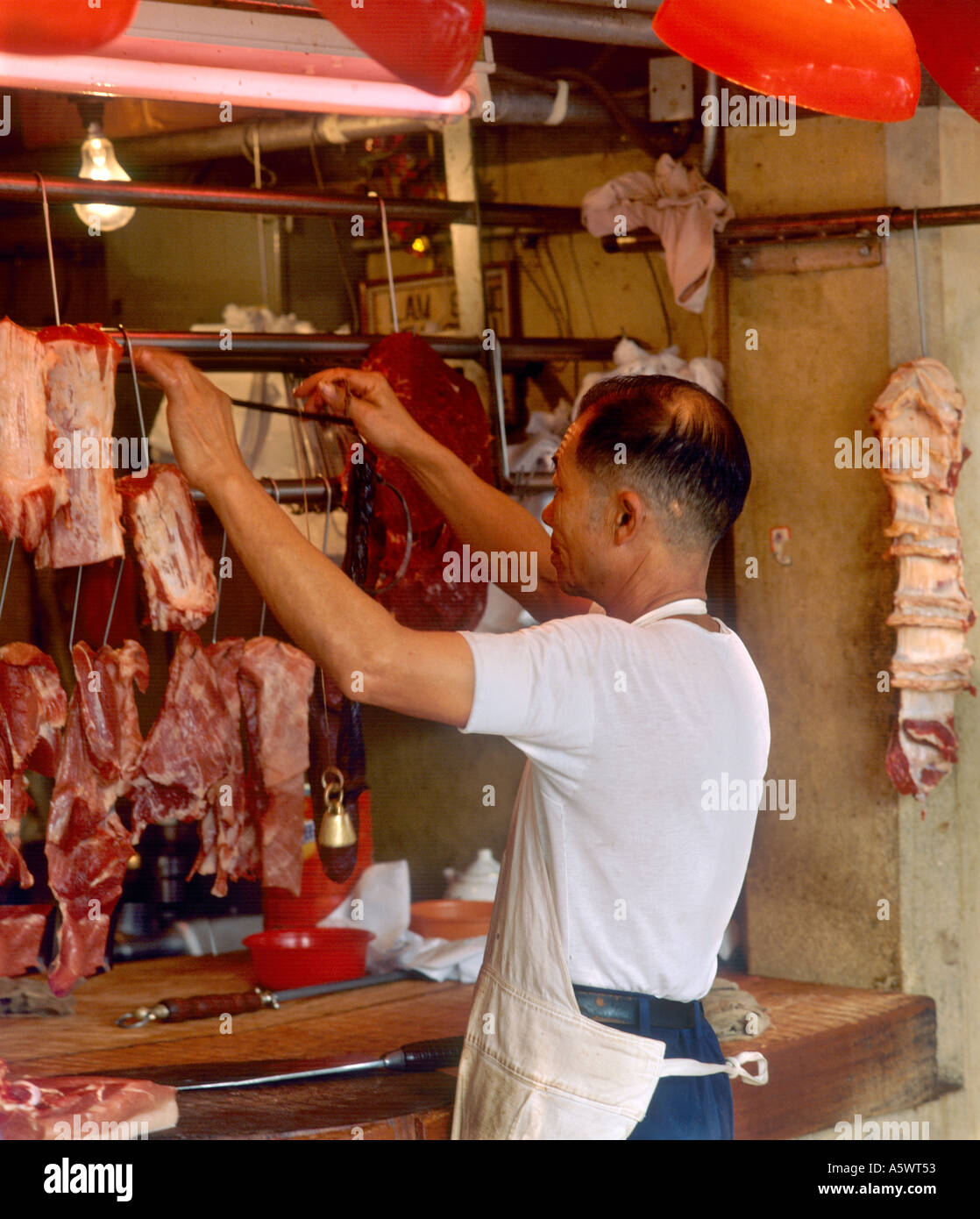 Butcher nel Mercato Stanley, Stanley, isola di Hong Kong, Hong Kong. Foto Stock