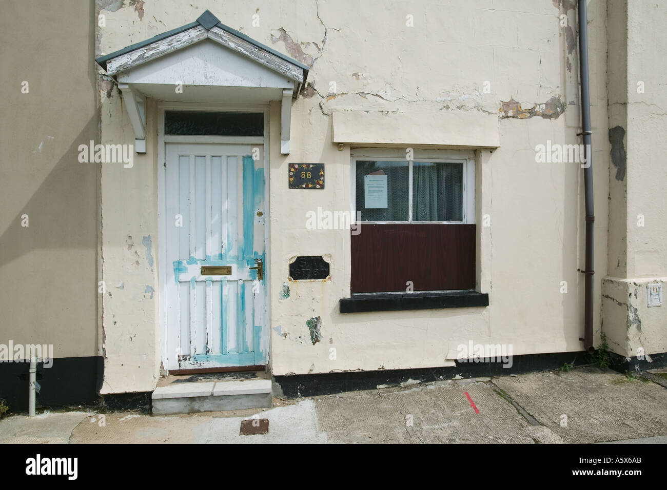 Vernice sbiadita e screpolata affacciata sulla casa a schiera di Blaenavon anteriore South Wales UK Foto Stock