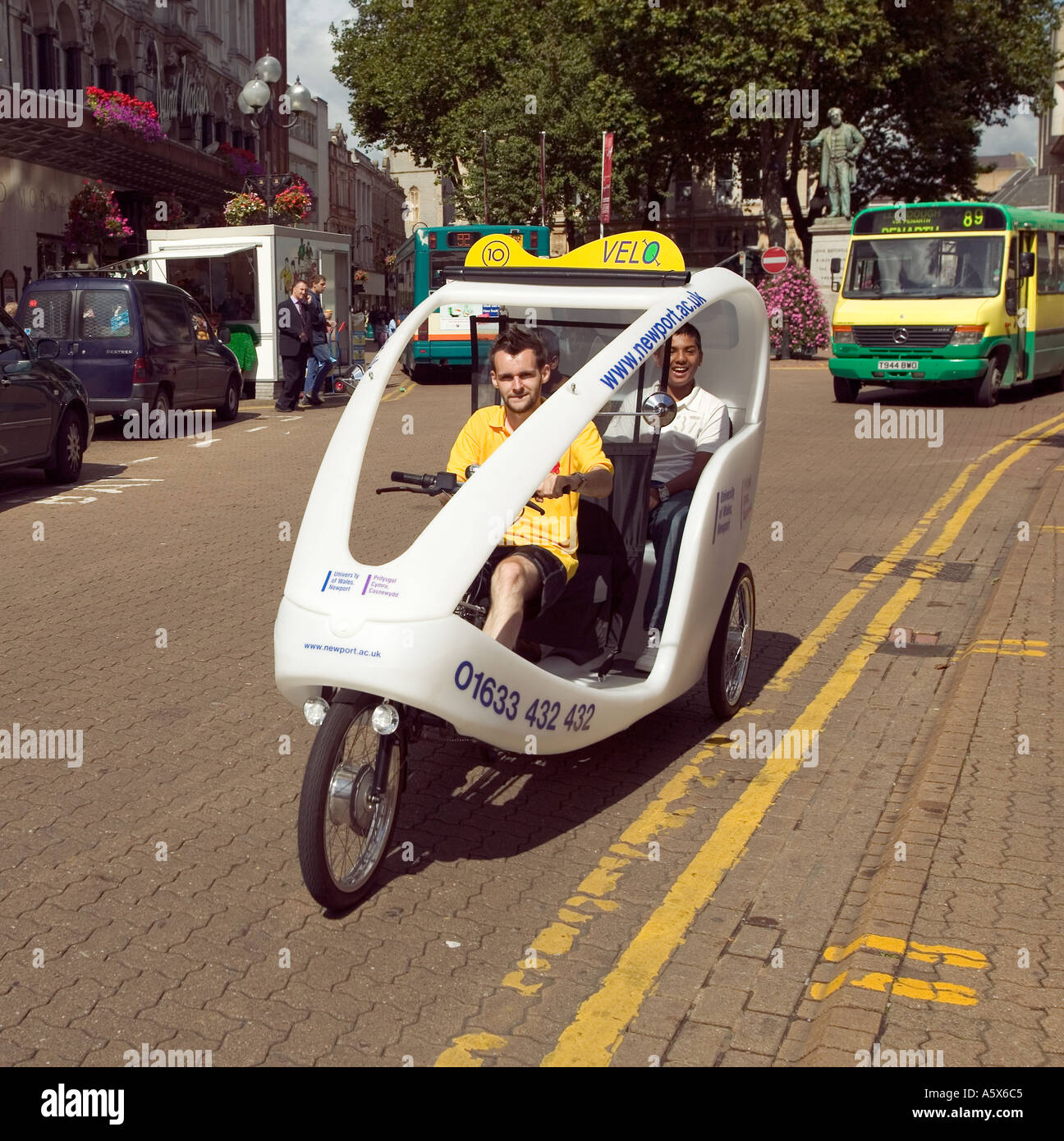 Il triciclo taxi con i mezzi di trasporto pubblico bus Cardiff South Wales UK Foto Stock