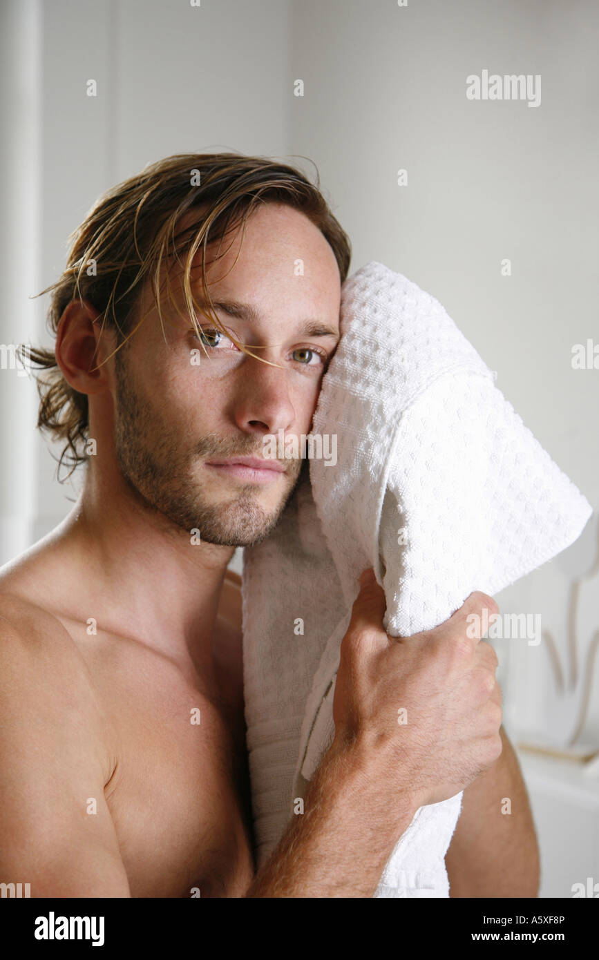 Giovane uomo asciugando il suo volto con asciugamano close up ritratto Foto Stock