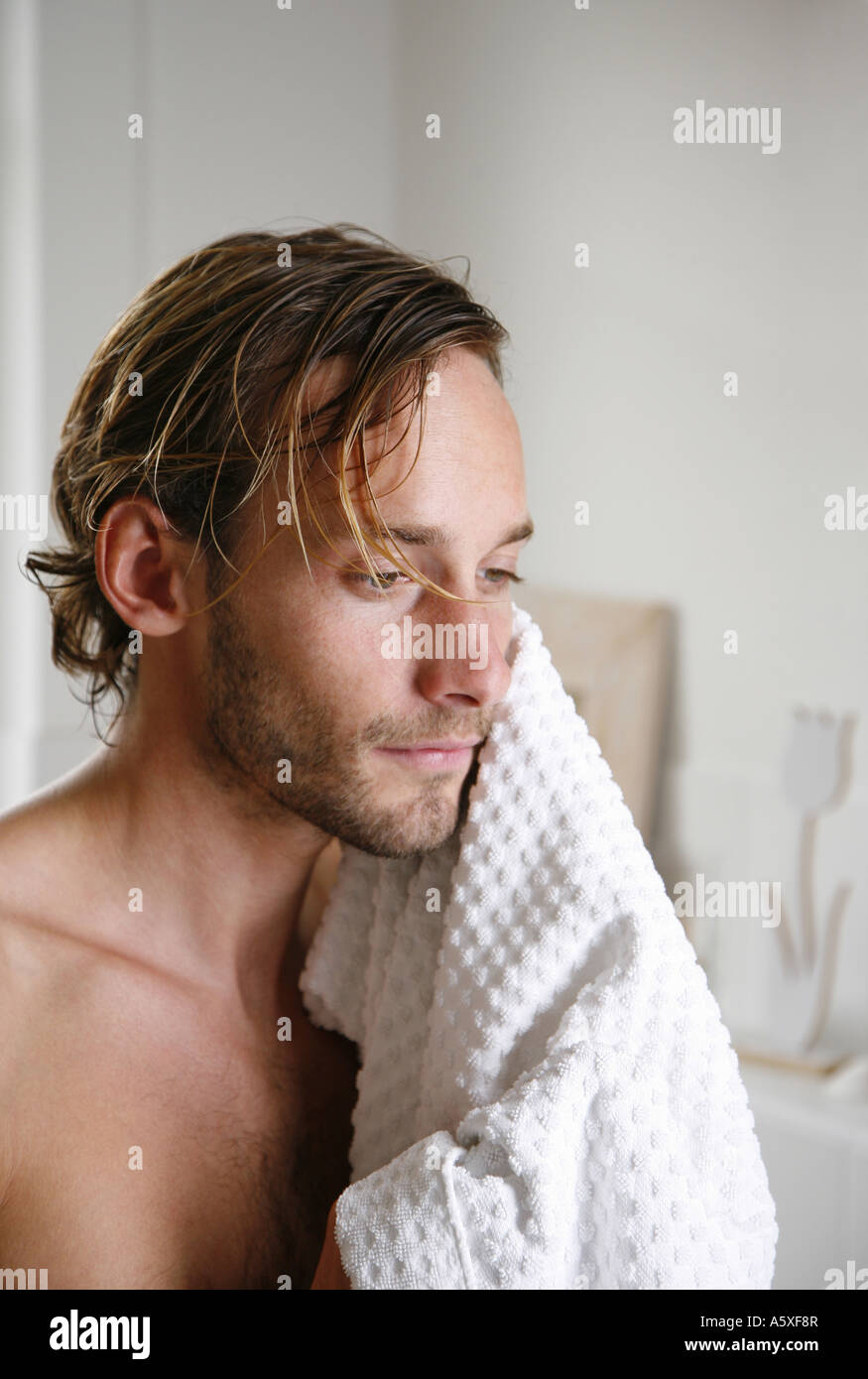 Giovane uomo asciugando il suo volto con asciugamano close up ritratto Foto Stock