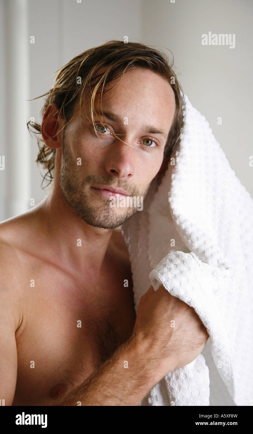 Giovane uomo asciugando i capelli con un asciugamano close up ritratto Foto Stock