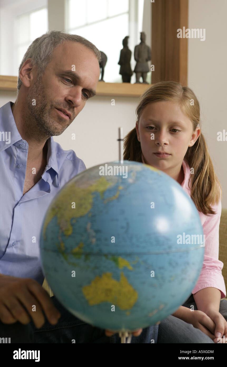 Padre e figlia che guarda sul globo terrestre Foto Stock