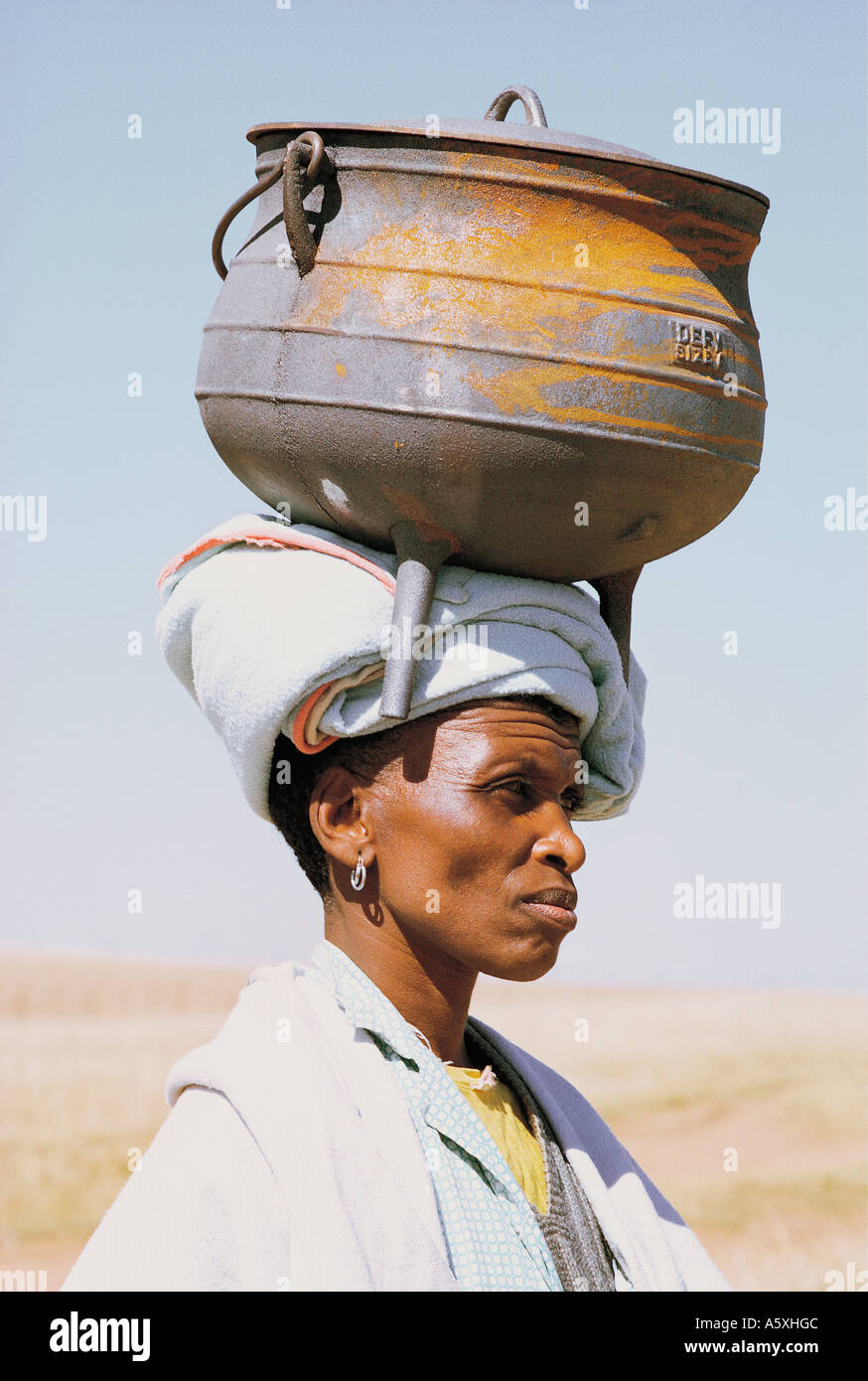 Xhosa donna che trasporta un ferro pentola di cottura sul suo capo Natal Sud Africa Foto Stock