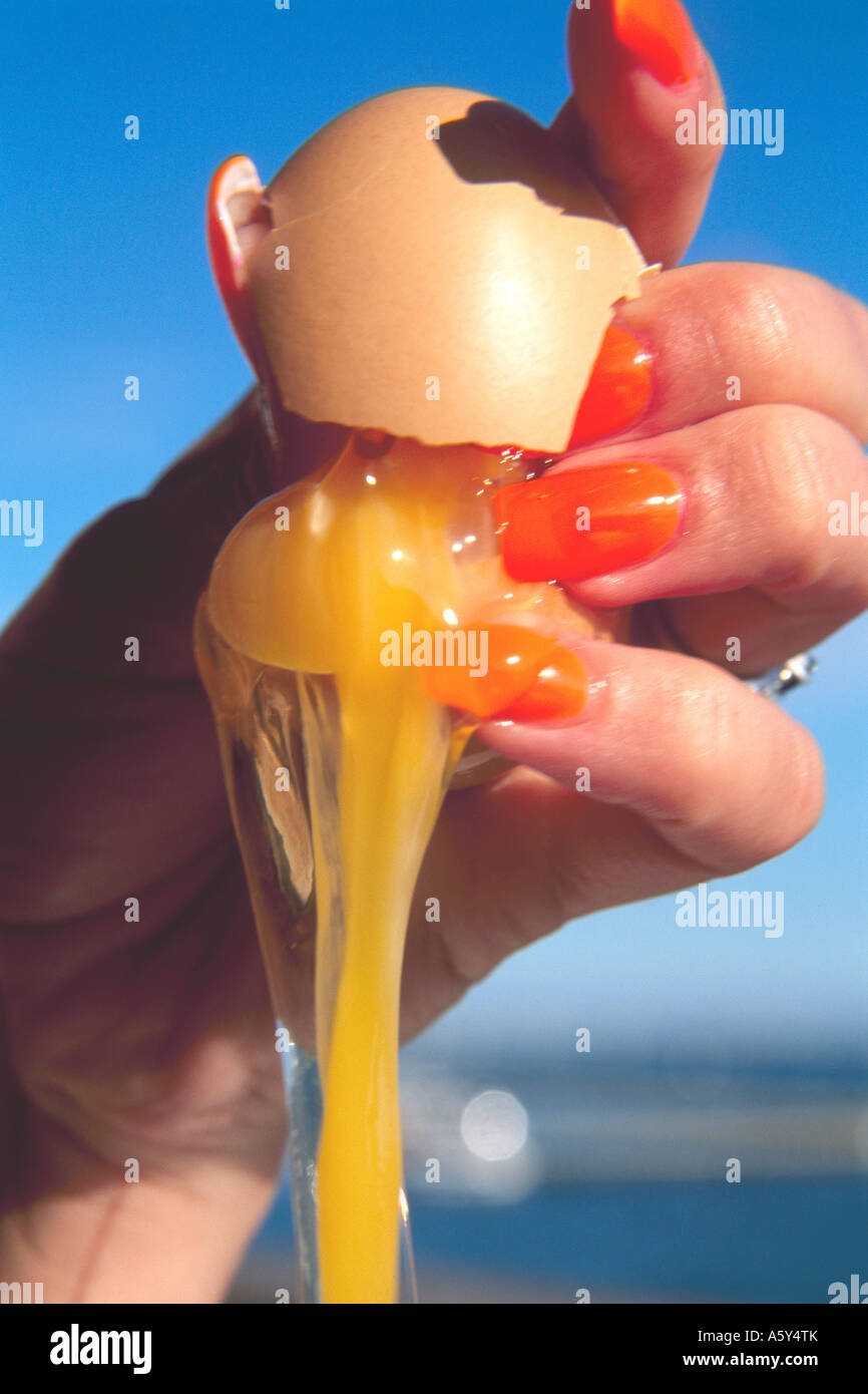 Donna con conseguente rottura di un uovo modello rilasciato Foto Stock