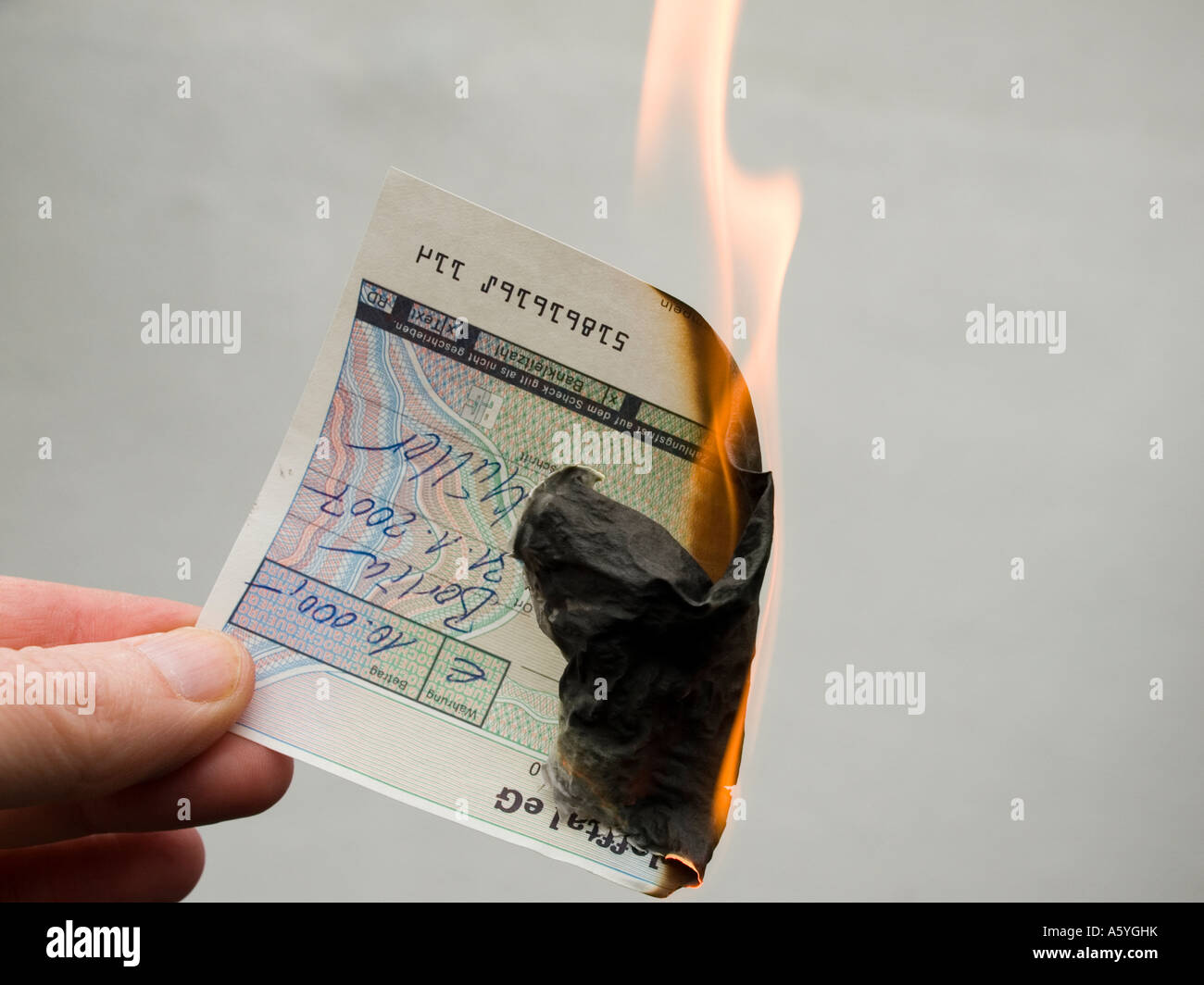 Mano che tiene un ardente controllare eurocheque Foto Stock