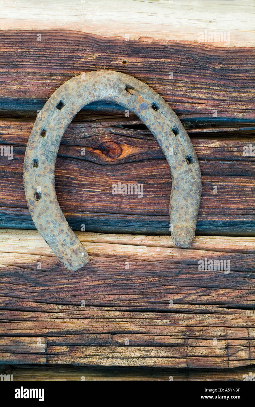 Il ferro di cavallo con il lato aperto rivolto verso il basso sulla parete di un blocco casa Fortuna cadere Foto Stock