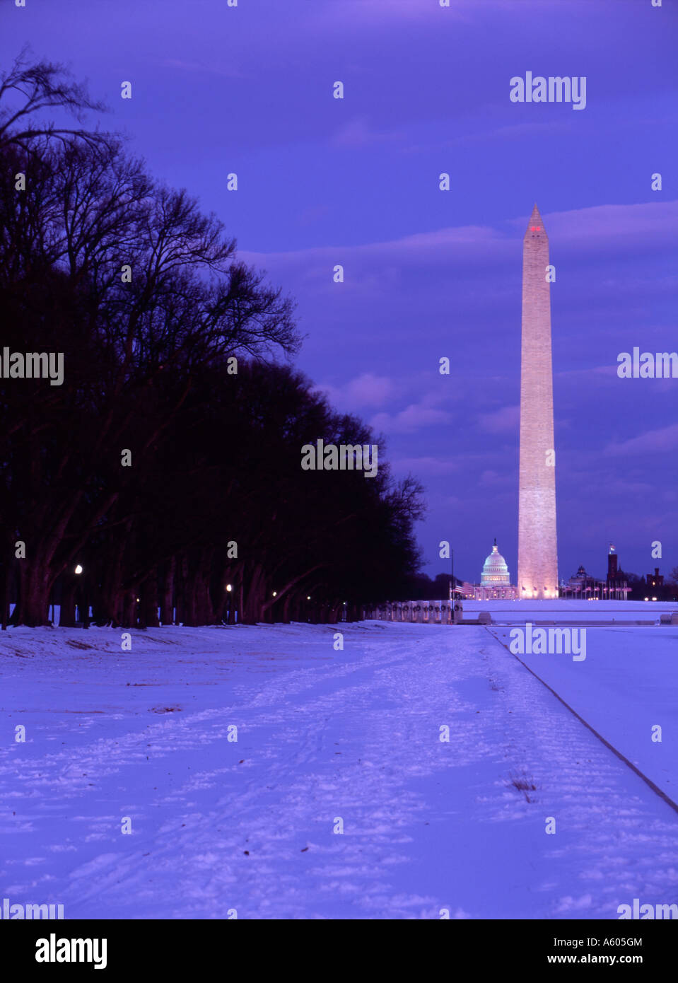 I riflettori il Monumento a Washington e il Capitol edifici al tramonto nella coperta di neve Mall. Foto Stock