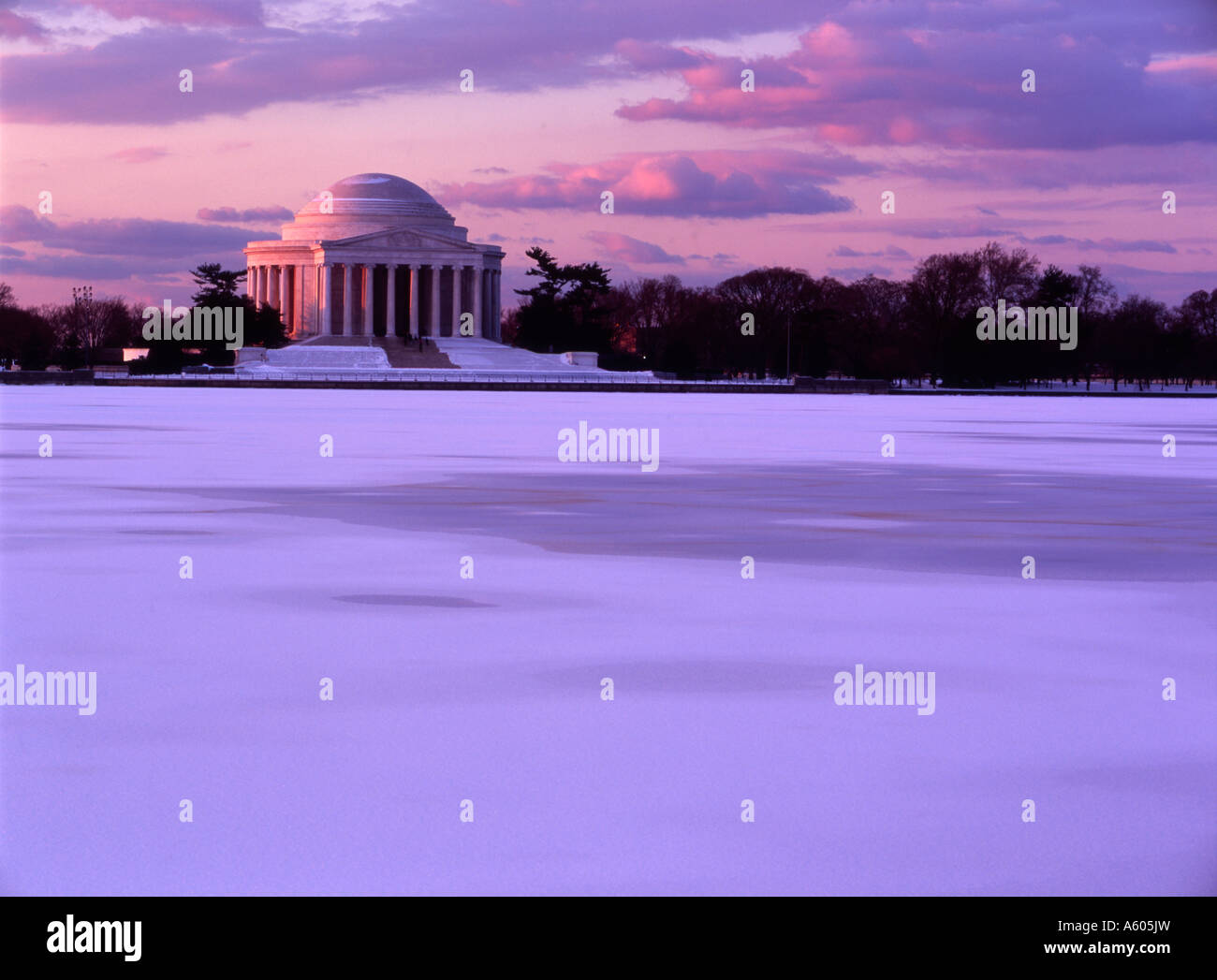 Una vista del Jefferson Memorial attraverso un congelati Tidal Basin contro una tonalità di rosa di una regolazione del sole Foto Stock