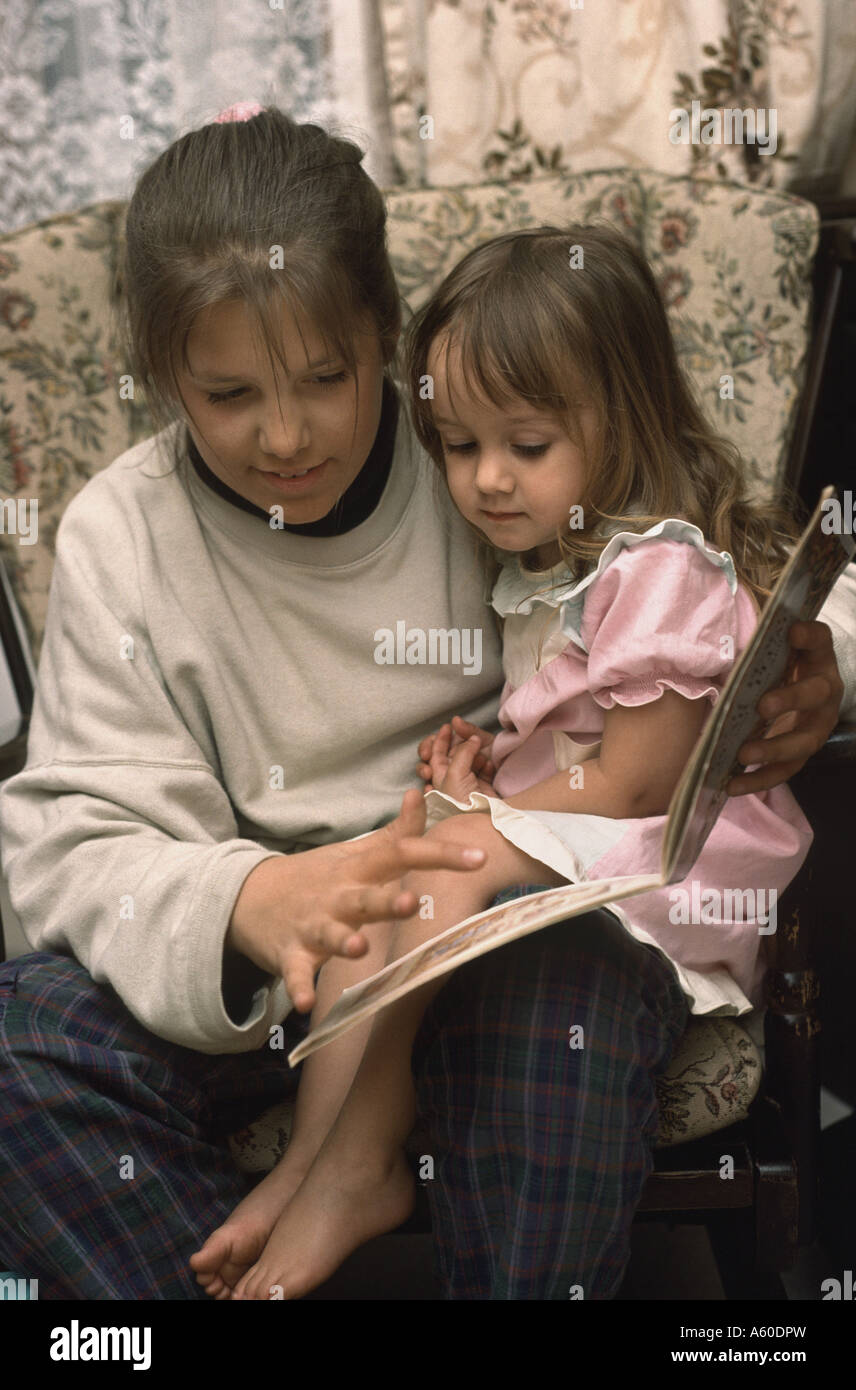 I giovani baby-sitter bambino la lettura di un libro Foto Stock