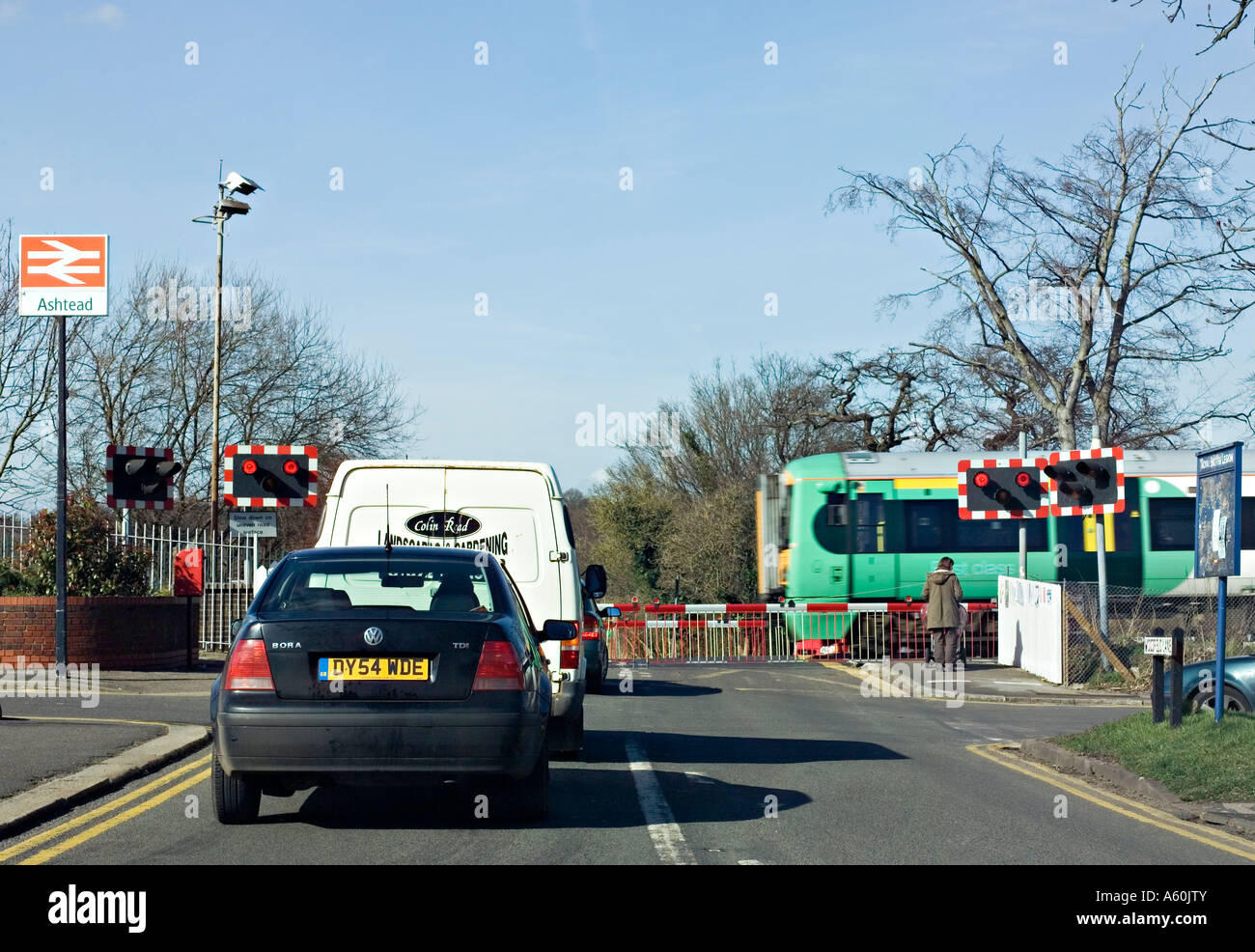 I veicoli in attesa in corrispondenza di un incrocio ferroviario nel Surrey, Regno Unito. Foto Stock