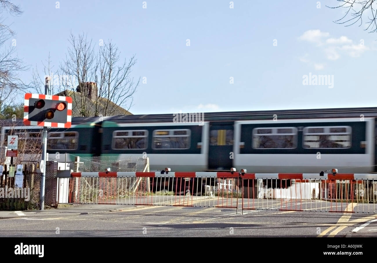 Un treno che passa su una strada che attraversa nel Surrey, Regno Unito. Foto Stock