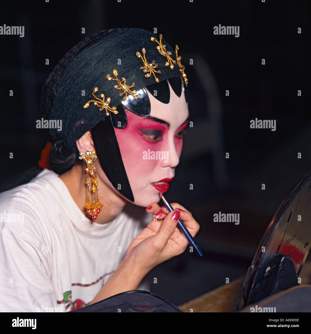 La donna si applica il trucco per outdoor opera cinese mostra al Clarke Quay dal fiume Singapore a Singapore Sud Est asiatico Foto Stock