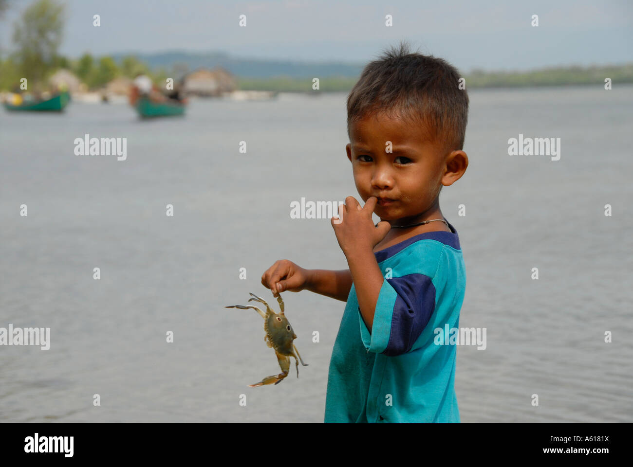 Ragazzo simpatico gioca con un granchio nella sua mano risma Parco Nazionale di Cambogia Foto Stock