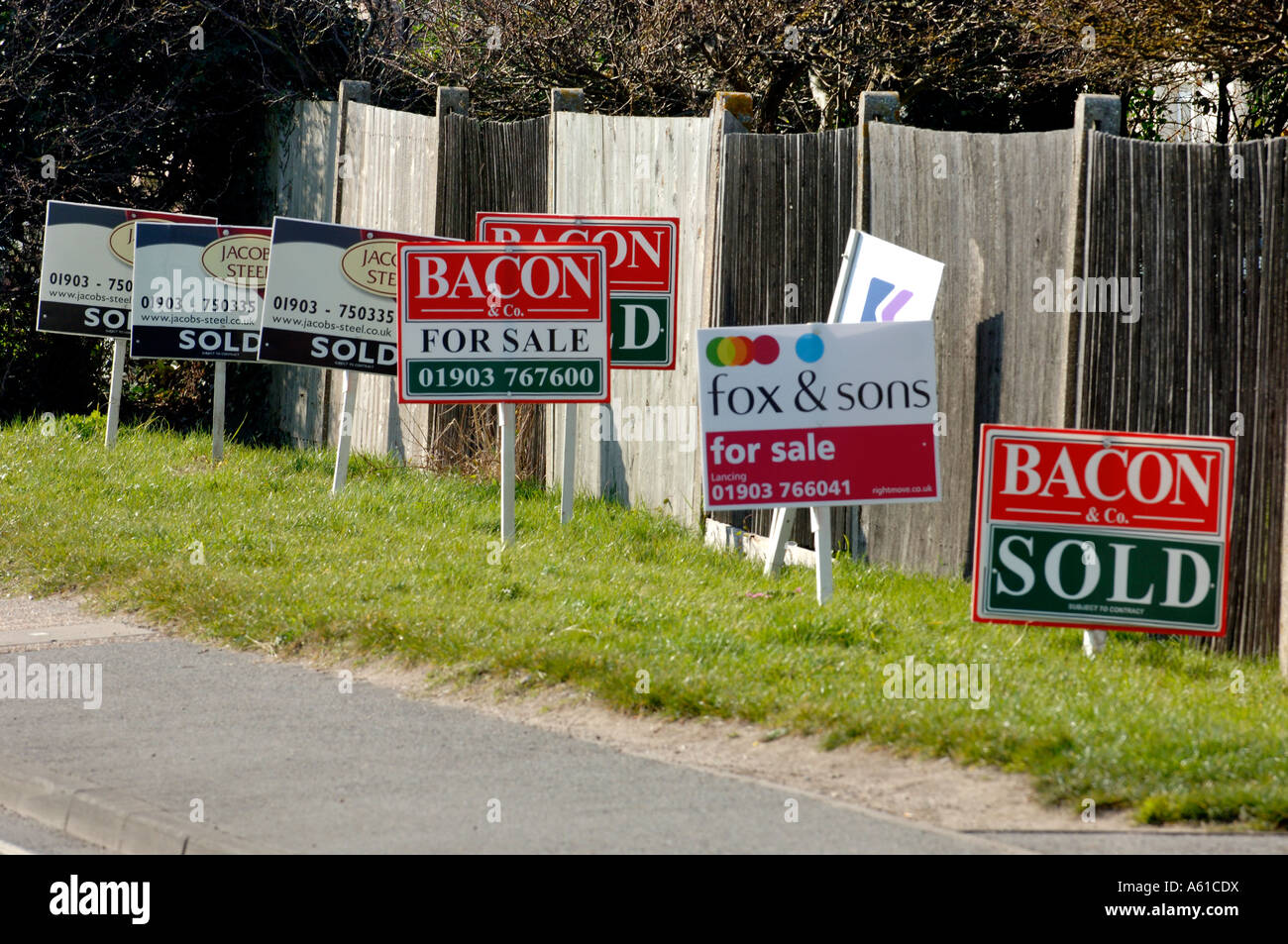 Una linea di agenti immobiliari in vendita e venduto firmare schede su una banchina Foto Stock Una linea di agenti immobiliari in vendita e venduto firmare schede su una banchina Foto Stock