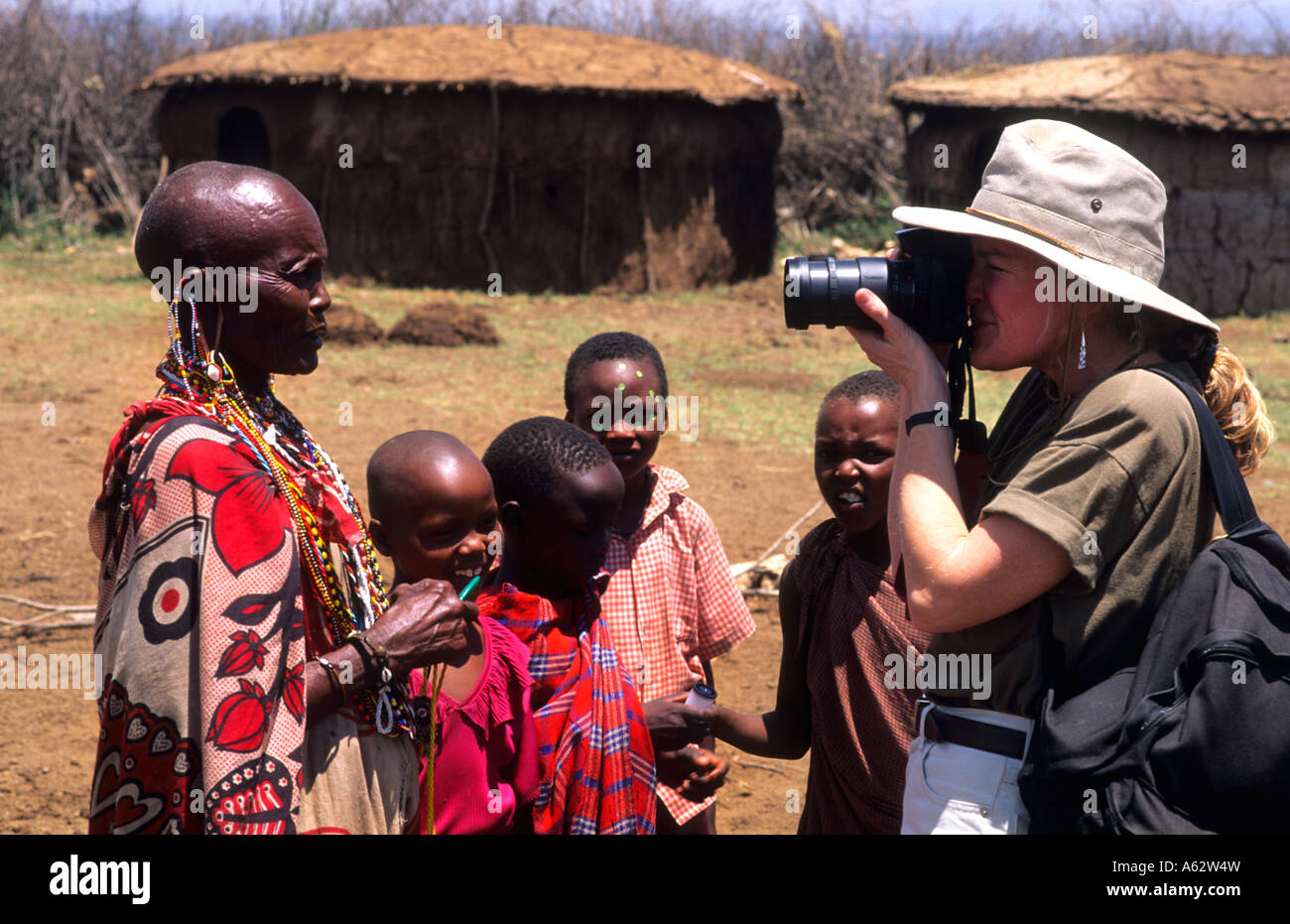 Turistica prendendo fotografie della tribù Masai gente in costume abito tradizionale nel villaggio vicino Kenya Africa Foto Stock