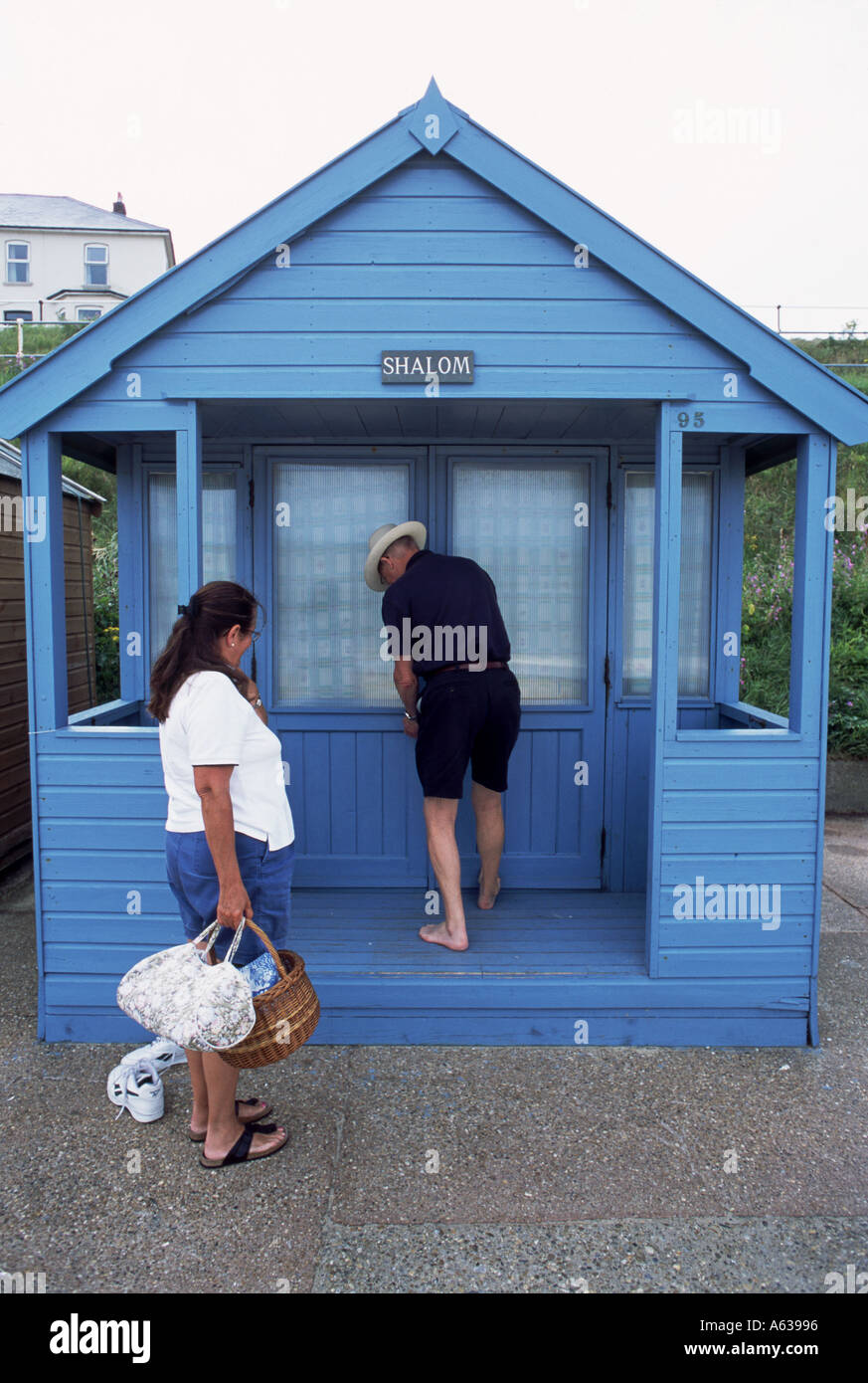 Custode di viaggio patrimonio Suffolk Coast Southwold aprendo l'holiday beach hut Foto Stock