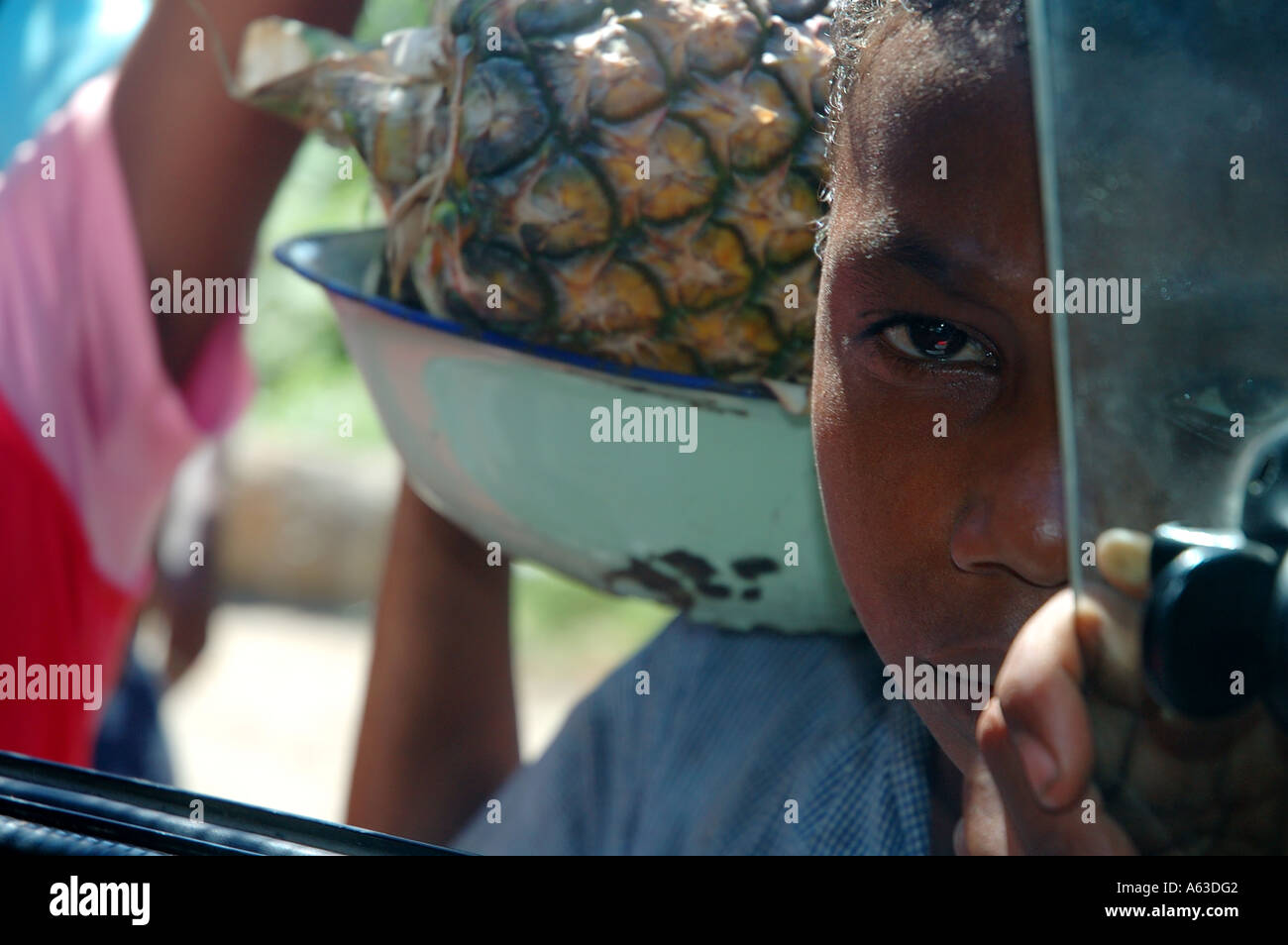 Ragazzo la vendita di ananas nel traffico Brickaville Madagascar n. MR Foto Stock