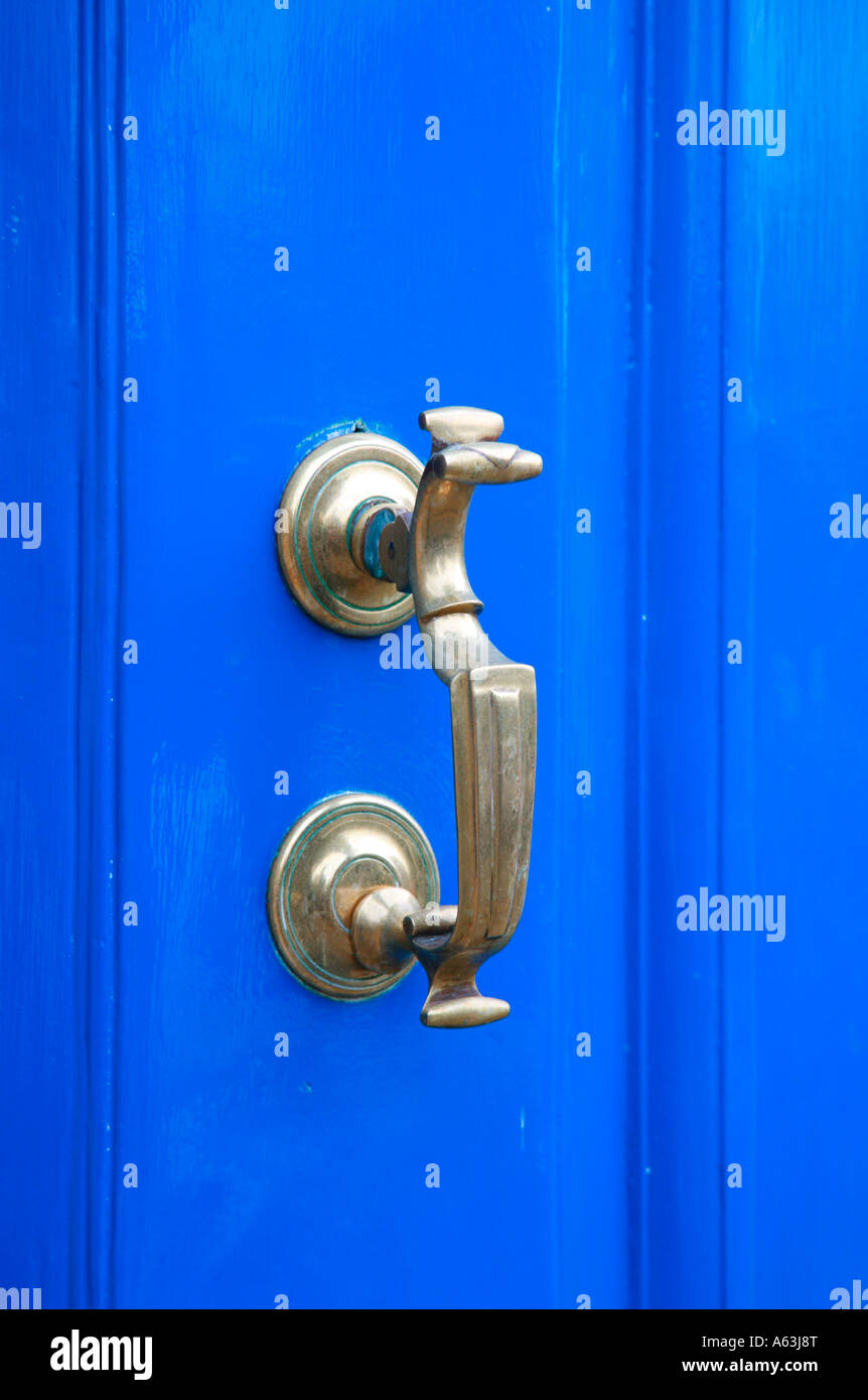 Porta in ottone respingente sul porta blu Foto Stock