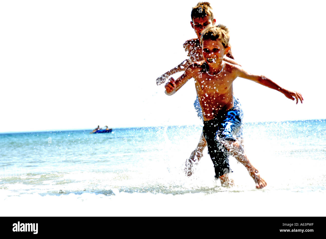 Due ragazzi giocare in acqua sulla spiaggia Foto Stock