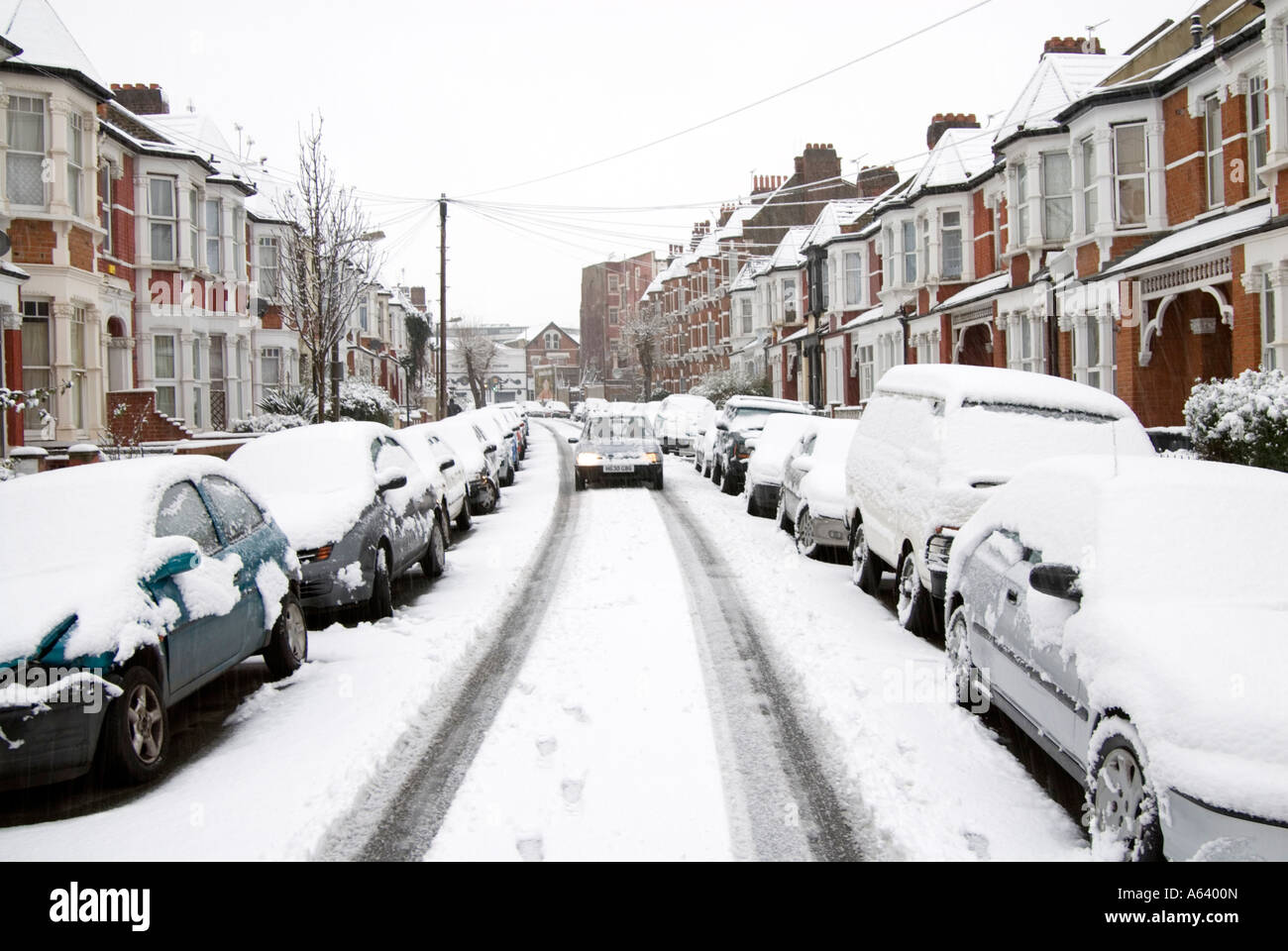 Coperta di neve auto in strada residenziale, Londra Inghilterra REGNO UNITO Foto Stock