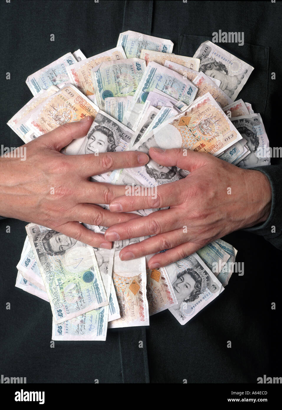 Il banchiere inglese ha le mani afferrato le banconote in contanti con sterlina inglese concetto finanziario "gatto grasso" "un sacco di soldi" "afferrare ciò che si può" avidità e avidità Foto Stock