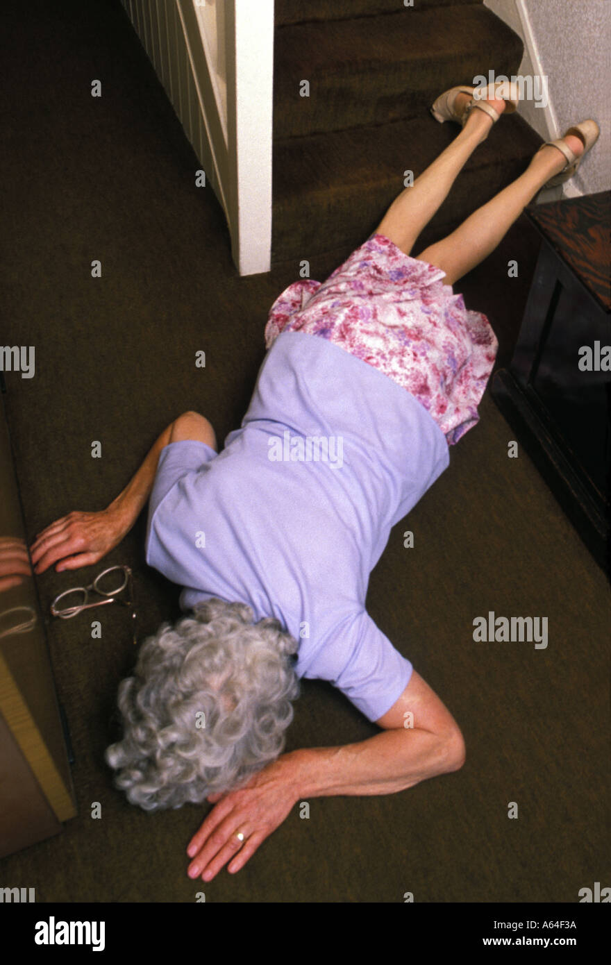 Donna anziana caduta o spinto giù per le scale Foto Stock