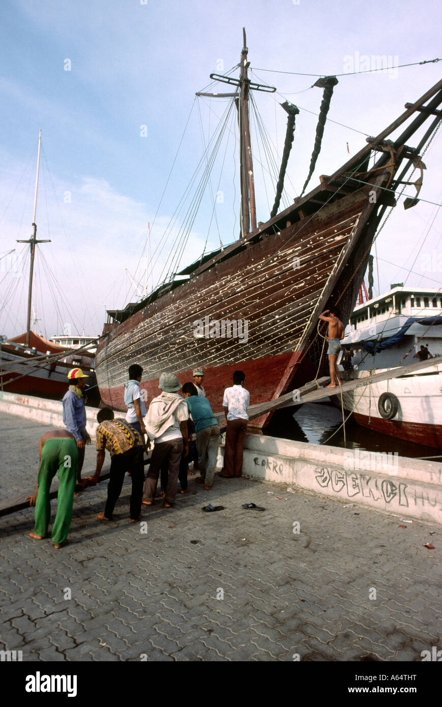 Java Indonesia Jakarta Sunda Kelapa Dock uomini gangplank sollevamento di legno nave a vela Foto Stock