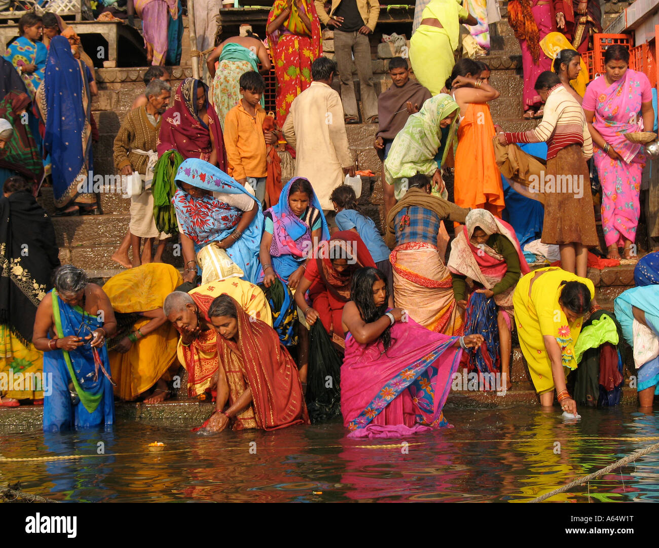 La gente di balneazione e pregando sul ghats del fiume Gange a Varanasi India Foto Stock