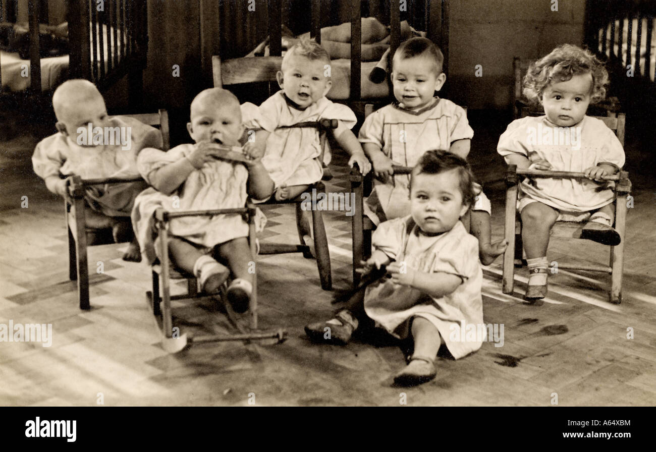 Inusuale immagine originale di sei bambini in un vivaio a Londra Est nei primi anni del 1900 probabilmente in un orfanotrofio di Barnardo, o reparto ospedaliero, Regno Unito Foto Stock