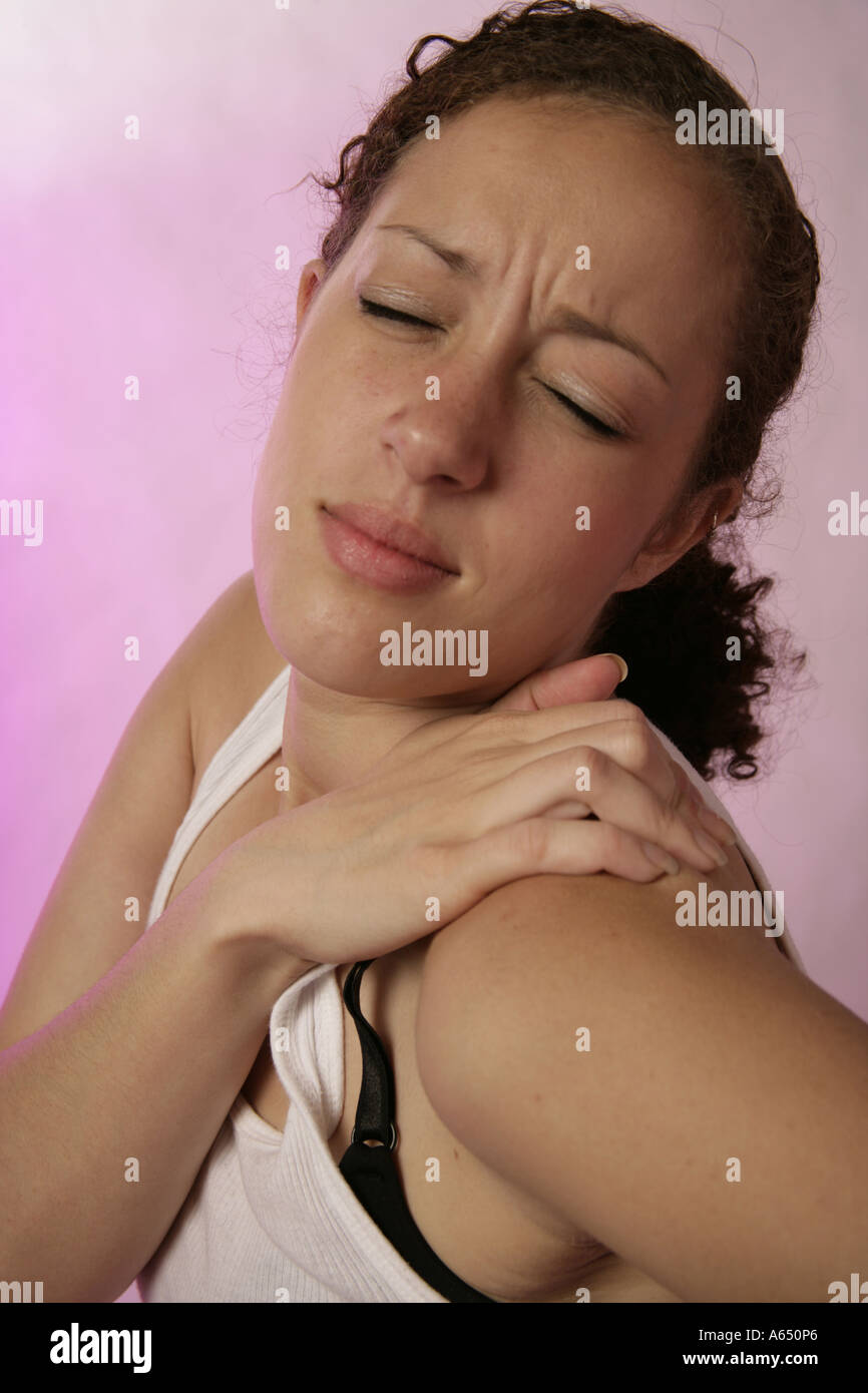 Giovane donna sperimentando dolore alla spalla. Foto Stock