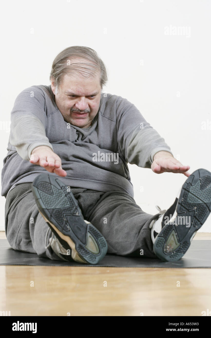 Il sovrappeso l uomo lavora fuori facendo si allunga e sit ups. Foto Stock