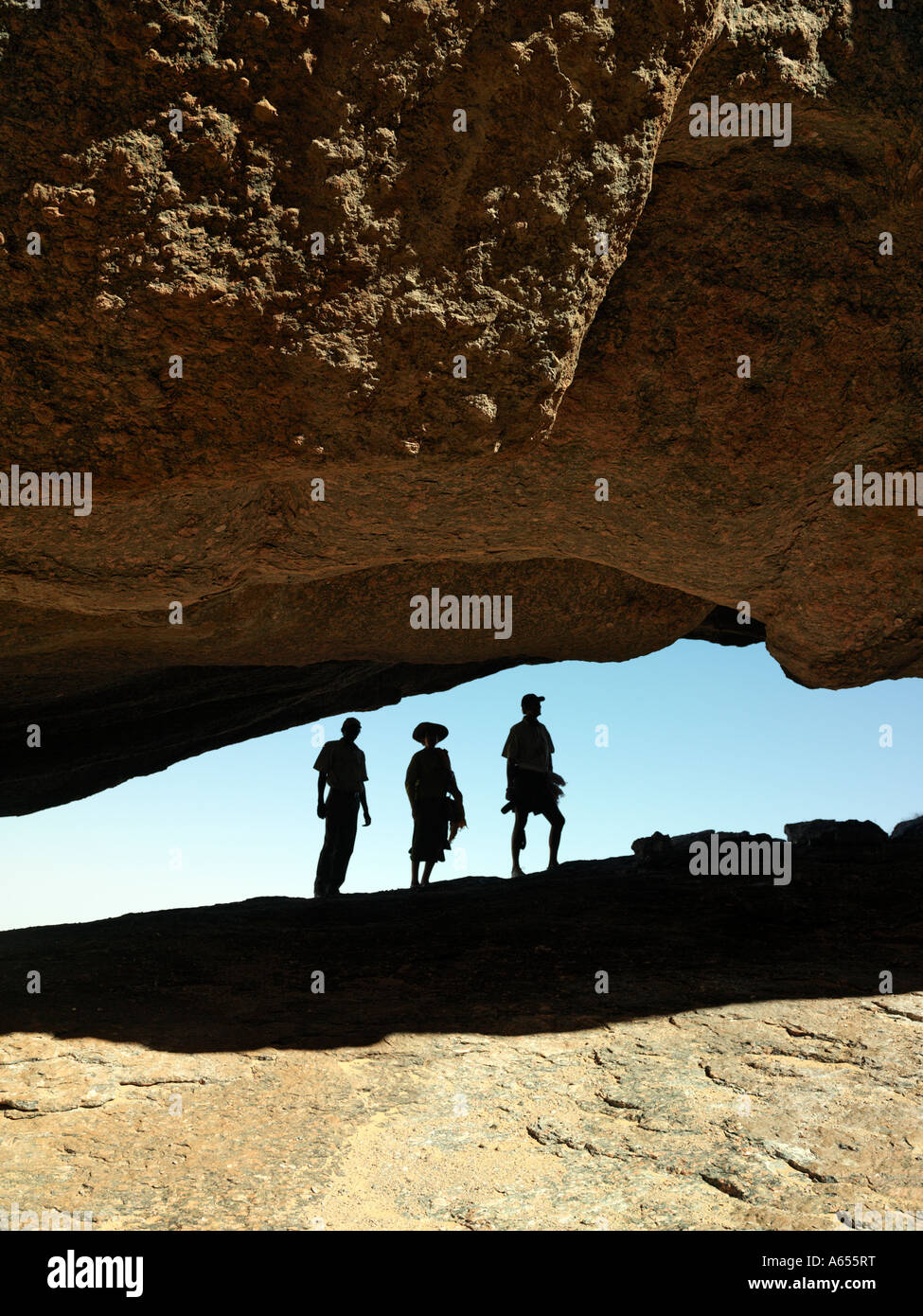 I visitatori ad una enorme roccia strapiombo massicci affioramenti di roccia sono una caratteristica di Hartmann s Valley in remoto a nord-ovest della Namibia Foto Stock