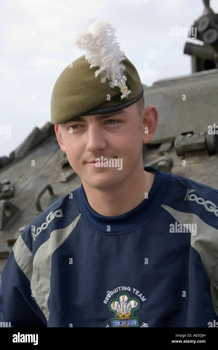 Giovane soldato maschio dal Royal Welsh reggimento team di reclutamento in piedi nella parte anteriore del blindato di trasporto di personale Foto Stock