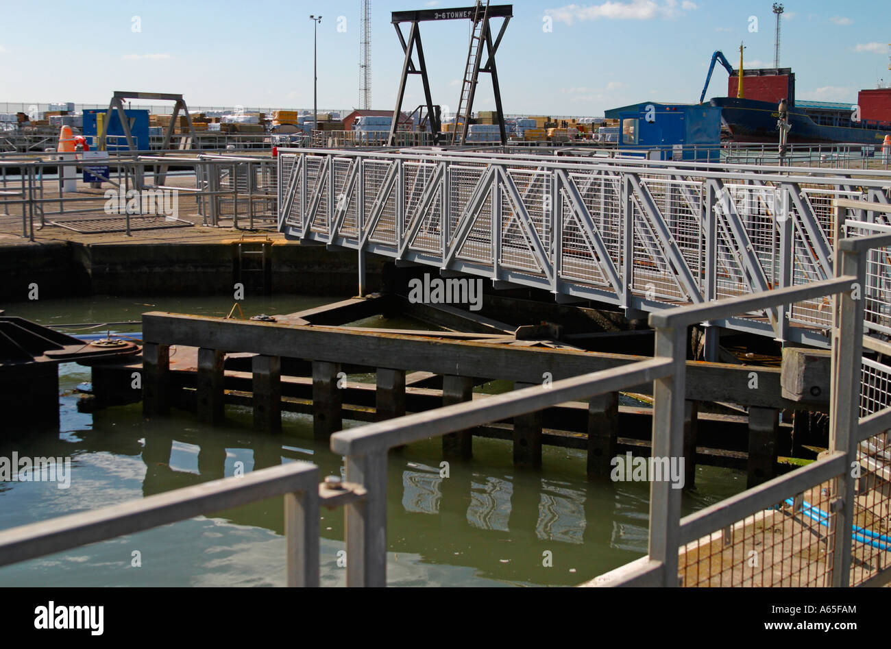 Cancelli di blocco al porto di Shoreham, Sussex, Regno Unito con il gantry crane in background Foto Stock