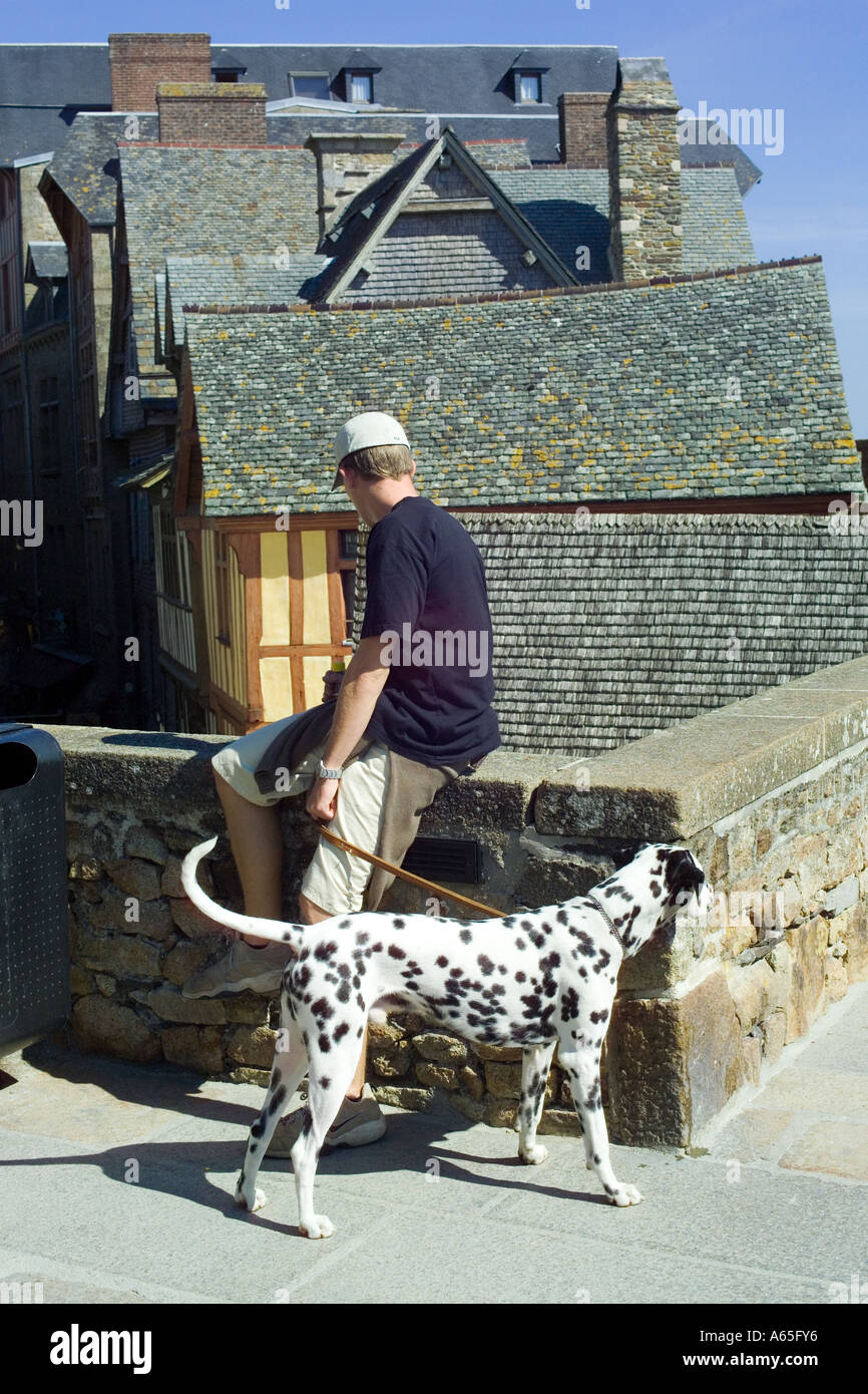UOMO , CANE DALMATA, REMPART, TETTI MEDIEVALI CASE ANTICHE, MONT-ST-MICHEL NORMANDIA FRANCIA EUROPA Foto Stock