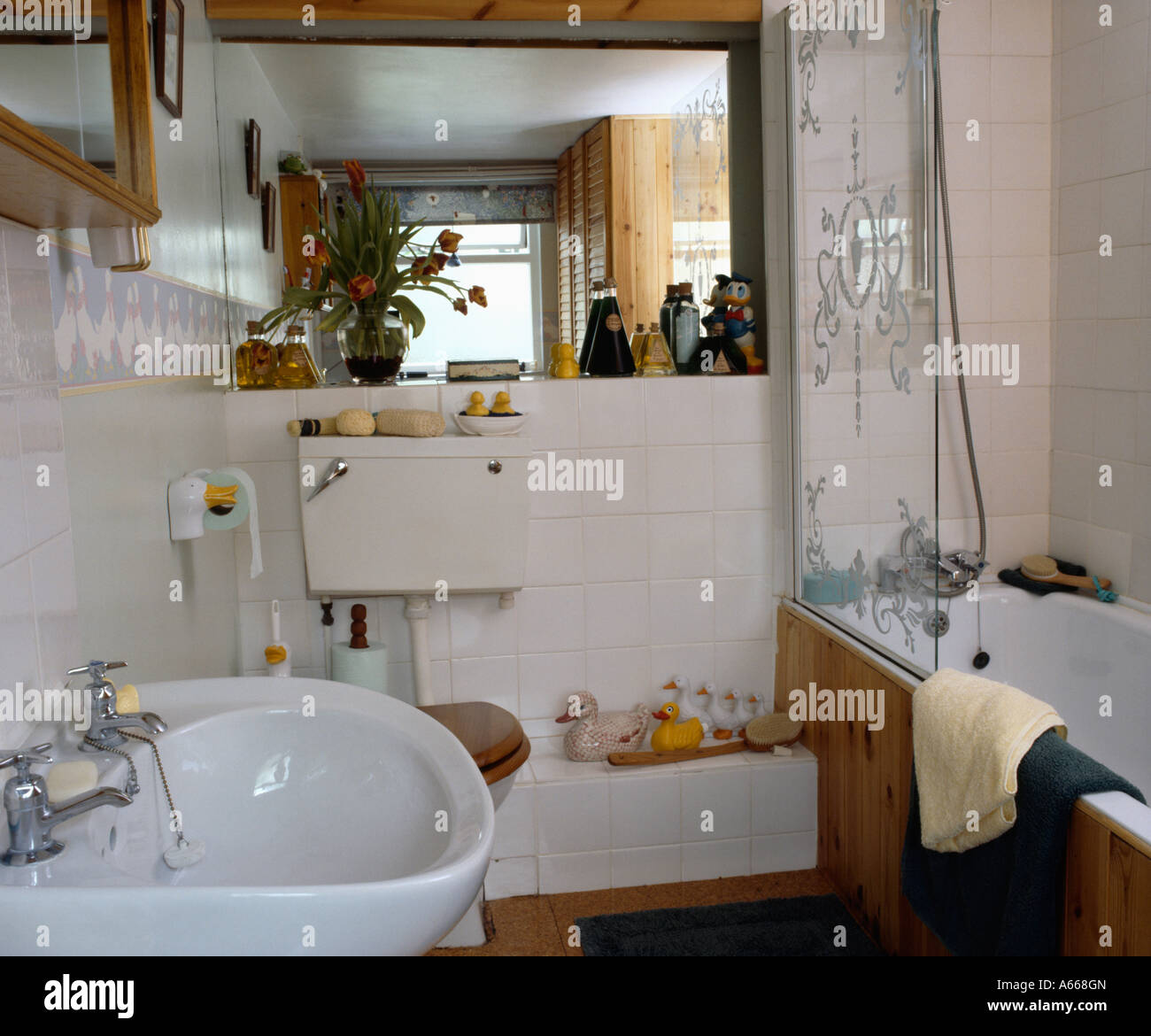 Inciso Il pannello di vetro in bagno in piccole stanze da bagno di colore bianco con grandi speculare Foto Stock