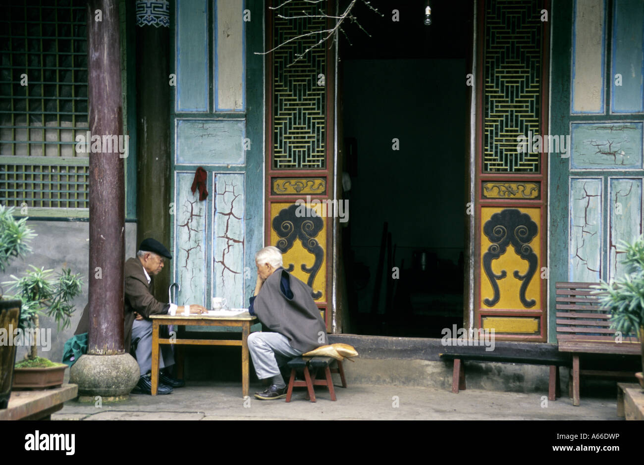 Due uomini anziani gioco di bozze nella parte anteriore di un tempio ingresso nella Xiu Shan park. Tonghai, nella provincia dello Yunnan in Cina Foto Stock