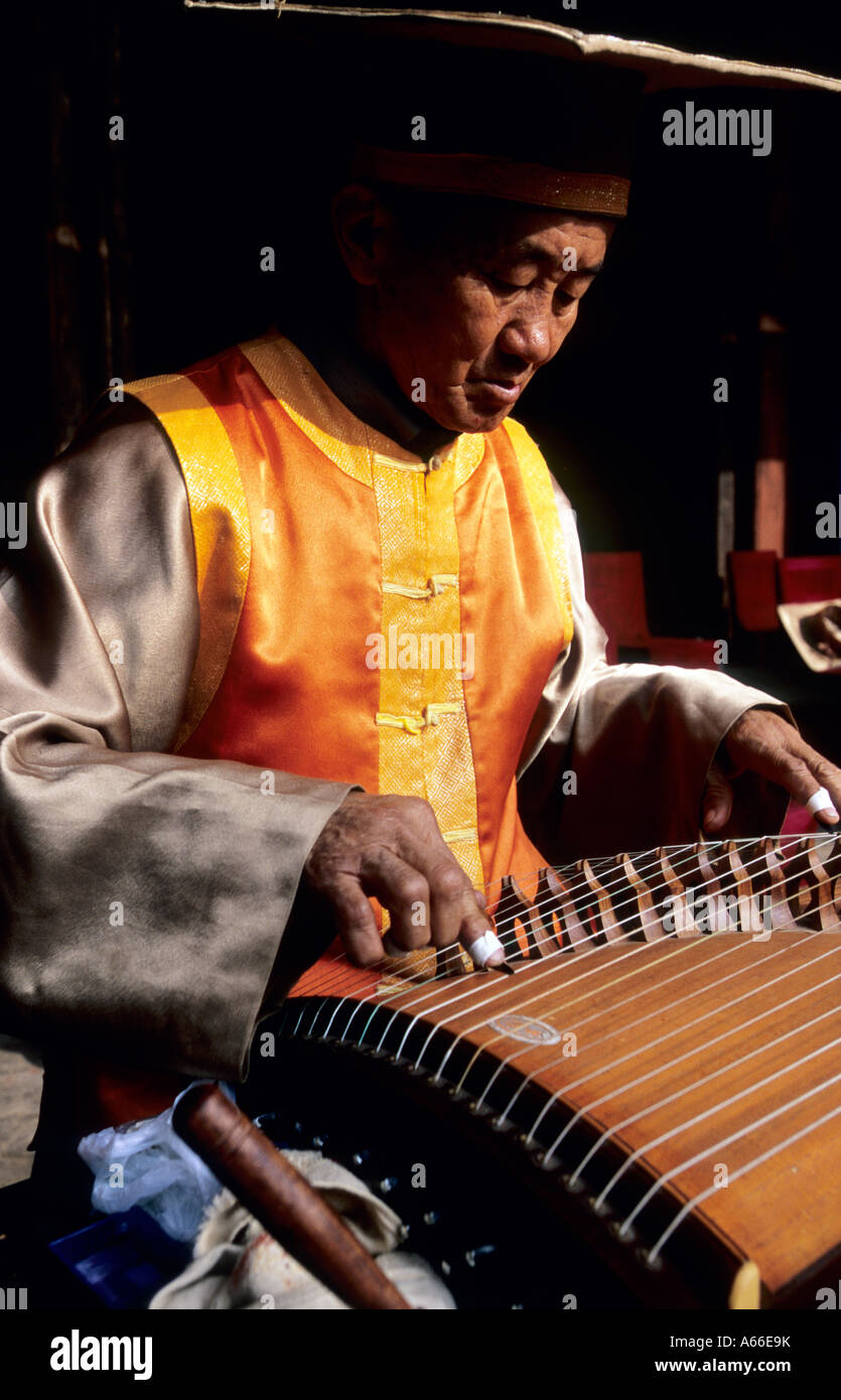 Musicista in abito tradizionale la riproduzione del Guzheng (Cinese cetra) nel tempio confuciano. Jianshui, Cina. Foto Stock