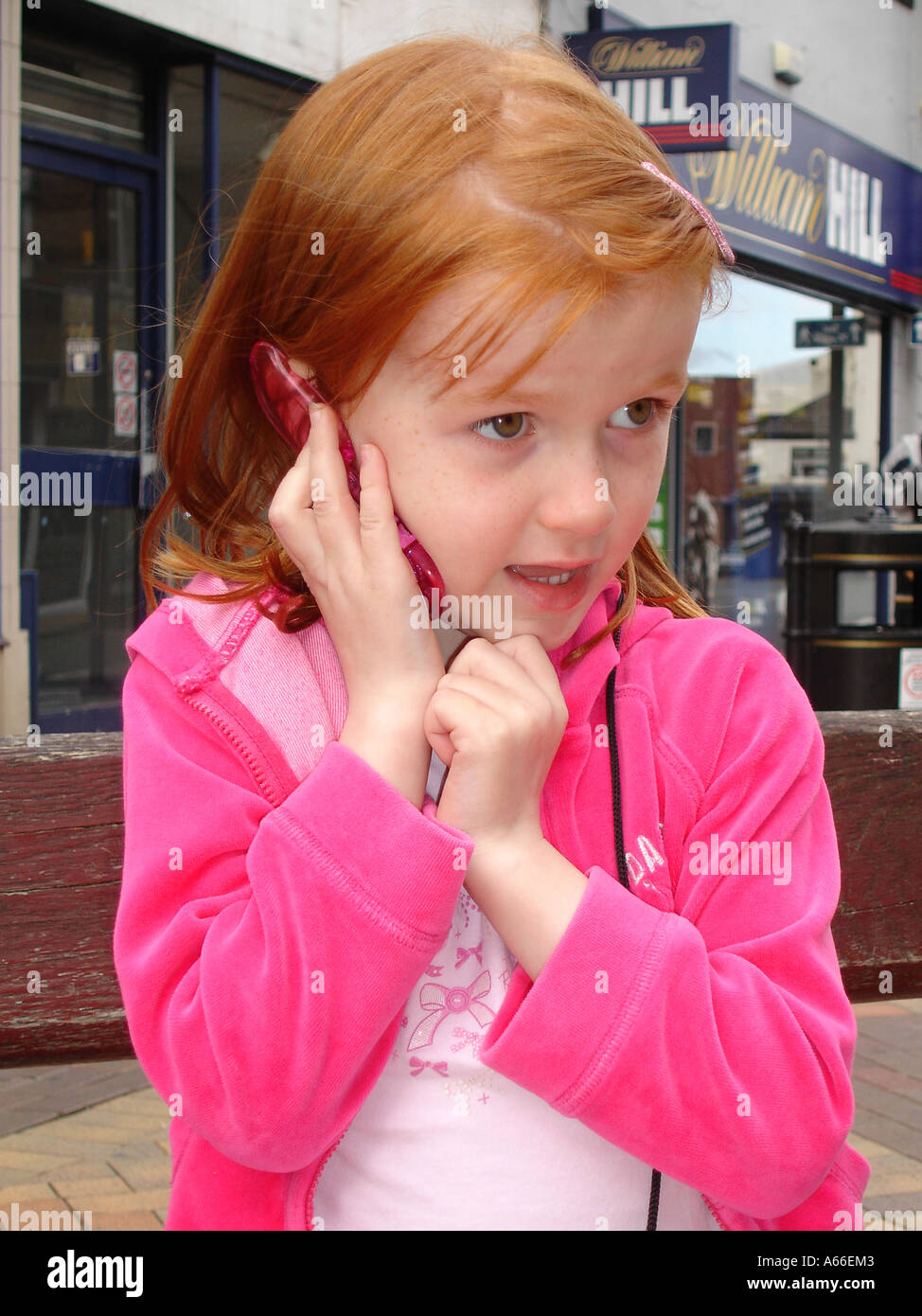 Bambina di cinque anni imitando utilizzando il telefono cellulare Foto Stock