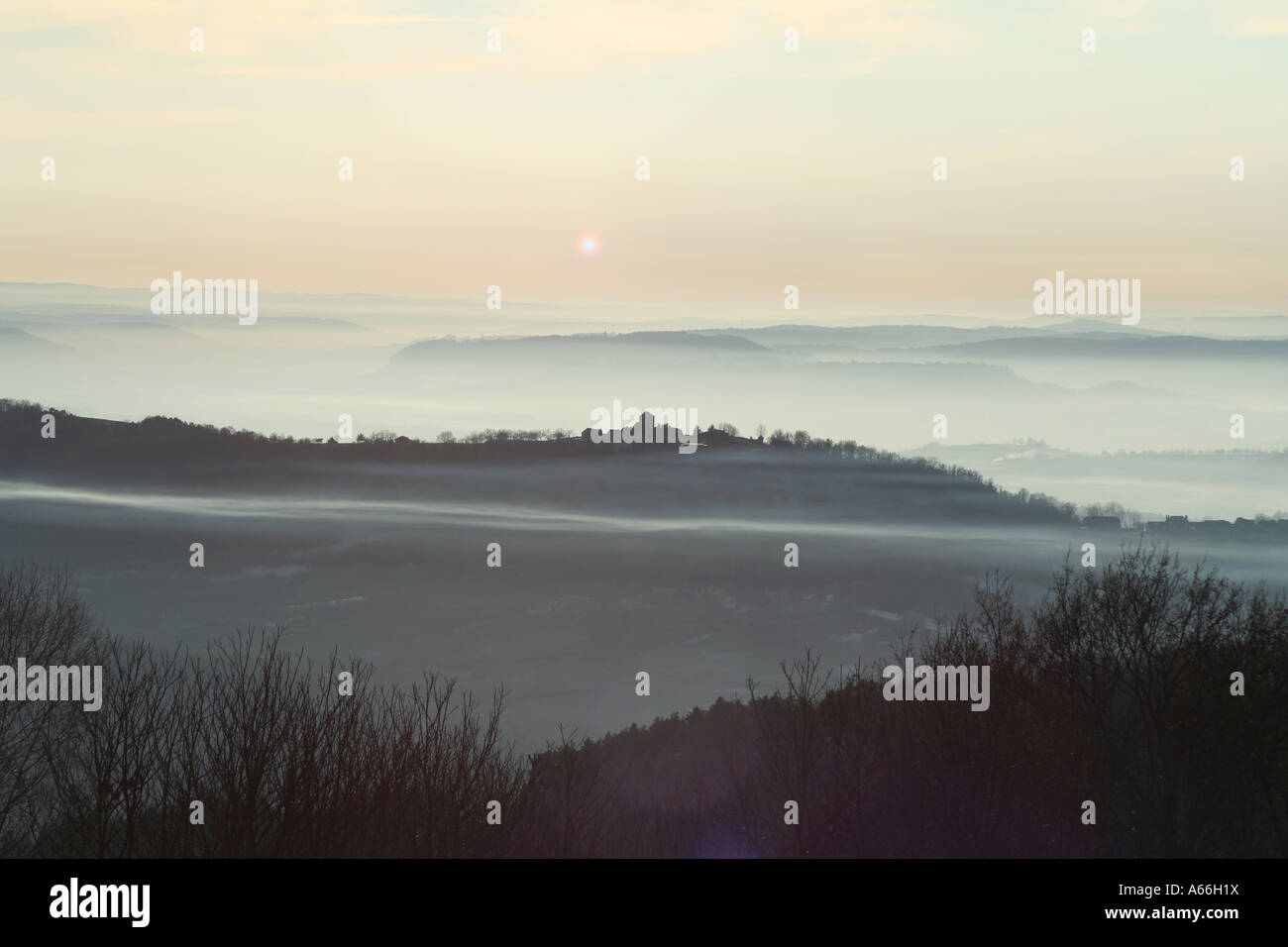 La striatura di nebbia andando attraverso il villaggio al tramonto Foto Stock