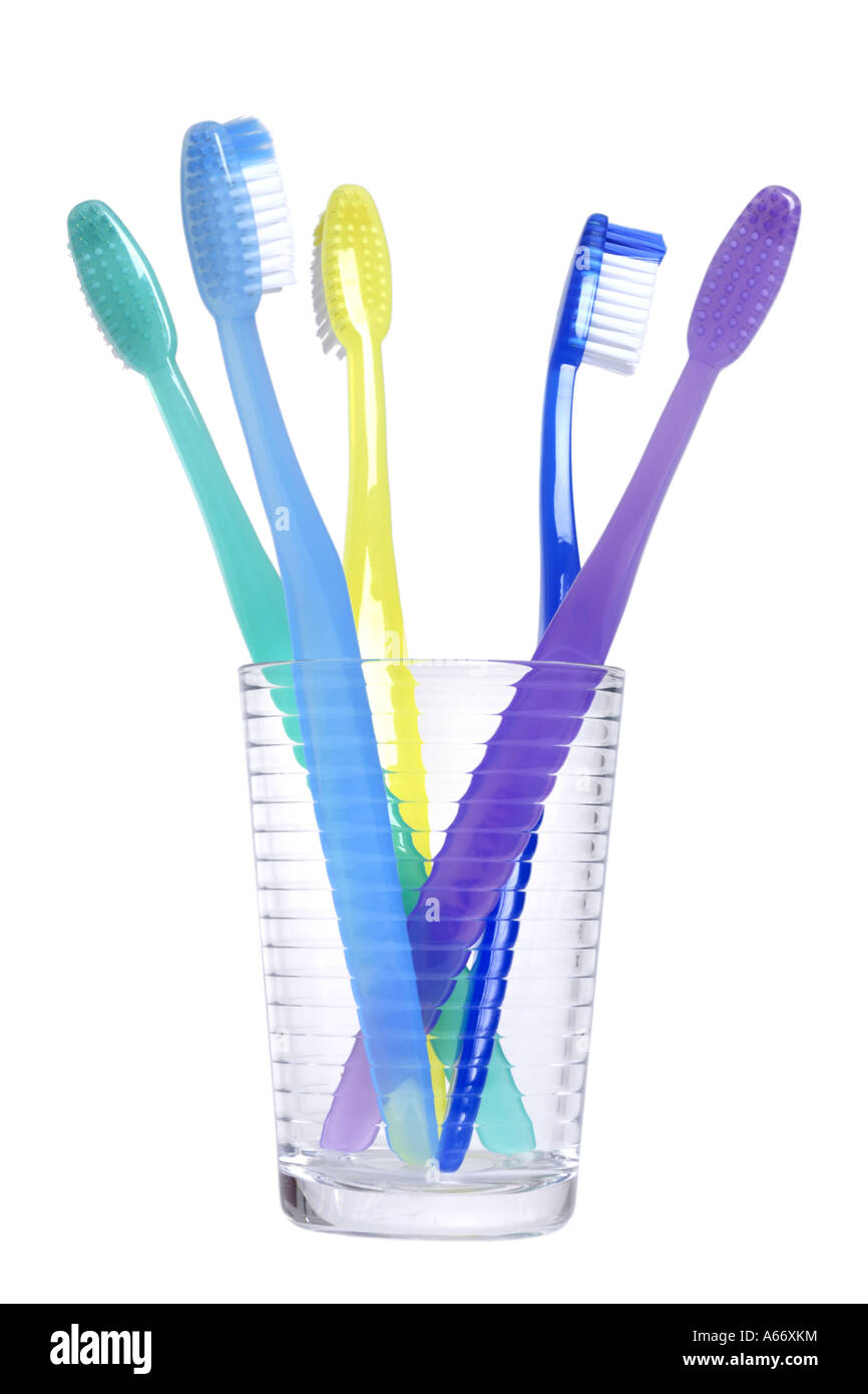 Cup con gli spazzolini da denti tagliati su sfondo bianco Foto Stock