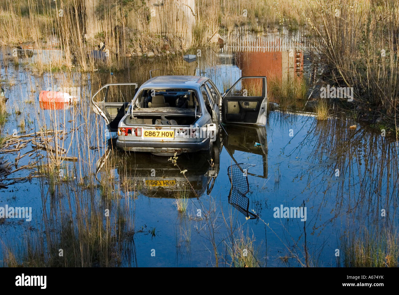 Oggetto di dumping auto su terreni incolti adiacenti ai Giardini Canbury, Kingston upon Thames, Surrey, Inghilterra, Regno Unito. Foto Stock