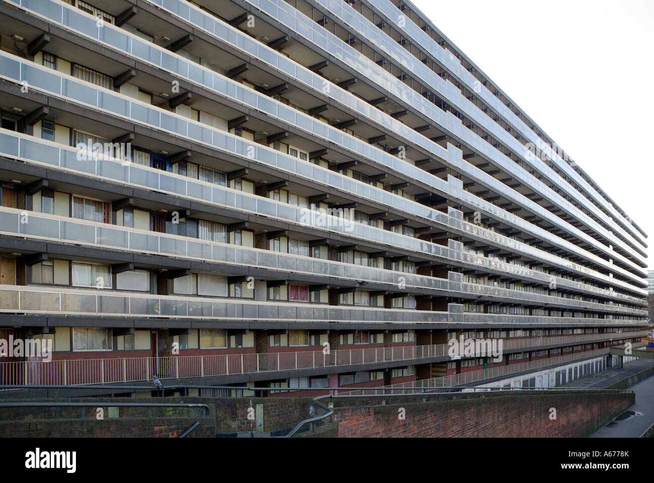 Lungo e alto blocco di abitazioni locali con balcone in comune accesso alle porte d'ingresso di Londra Inghilterra Regno Unito Foto Stock