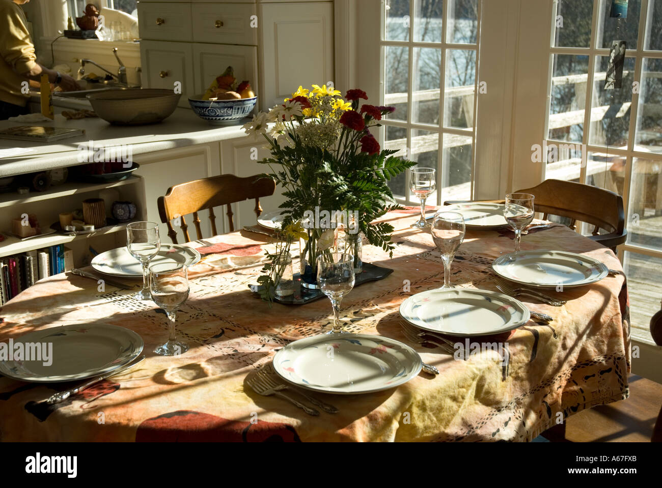 Sala da pranzo con cena impostazione e traliccio windows con sun versando in. Foto Stock