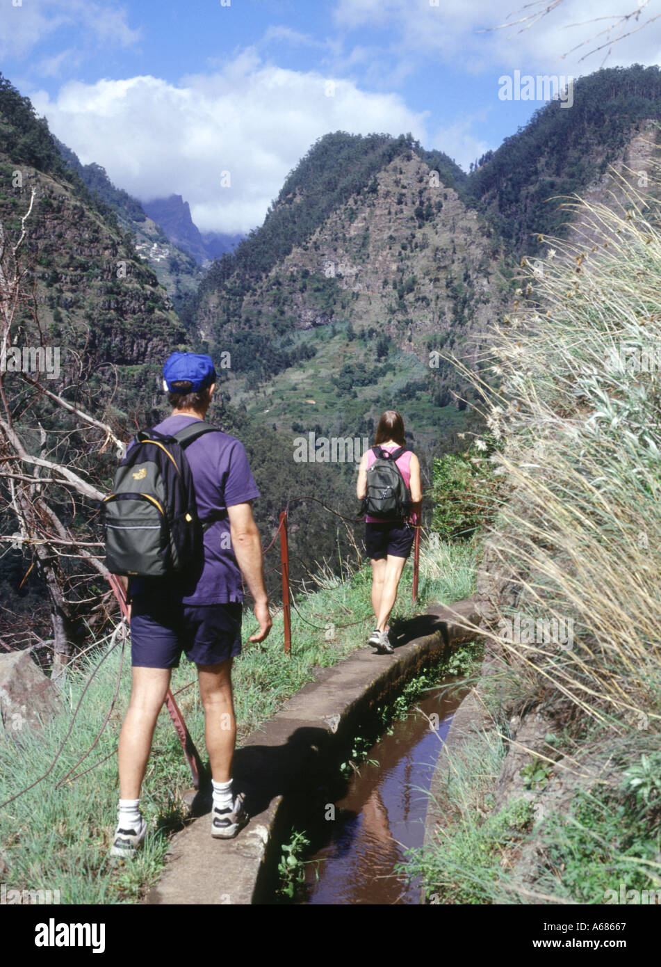 dh Levada dos Curral SOCORRIDOS VALLE MADEIRA Walkers escursionismo Levadas maschio femmina vacanza turisti ramblers sentiero a piedi persone turismo Foto Stock