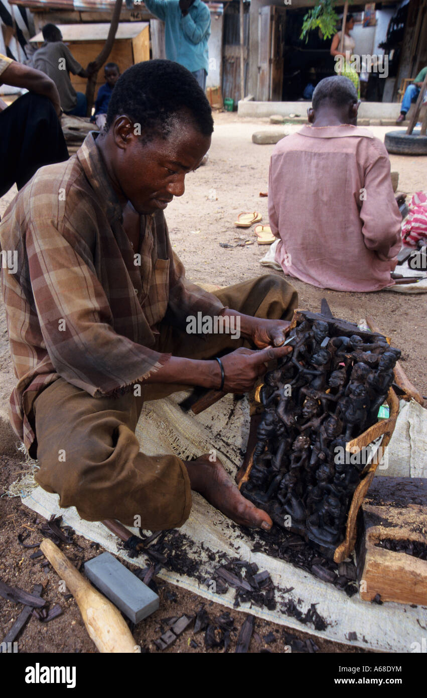 Makonde carver con ebano carving al mercato Mwenge, Dar es Salaam, Tanzania Foto Stock